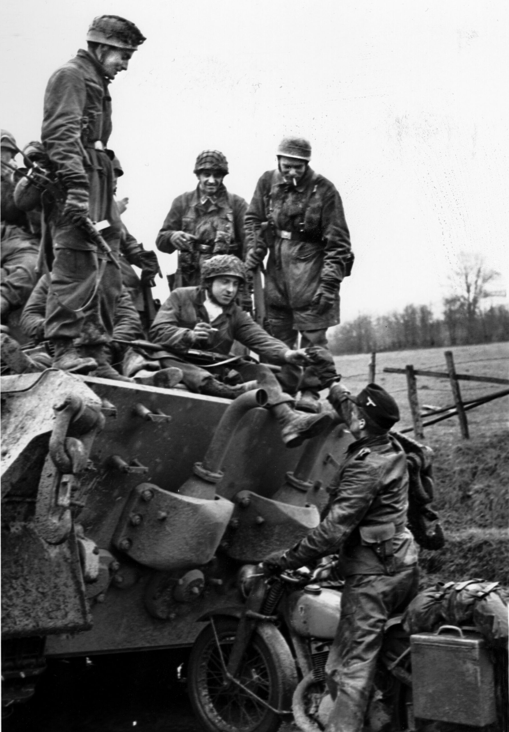 Armed with a variety of German and captured weapons, a group of Fallschirmjäger roll through Liegneuville, Belgium to rejoin the main body of Kampfgruppe Peiper.