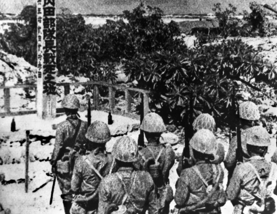 Japanese troops stand at attention to honor their fellow soldiers who were killed in the stubborn American defense of Wake Island. 