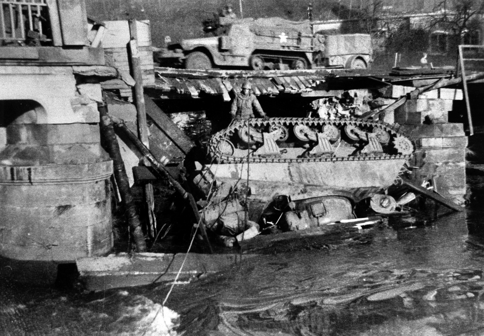 A 33-ton Sherman from the 11th Tank Battalion has broken through a bridge over the Alzette River in Luxembourg, January 1945. 