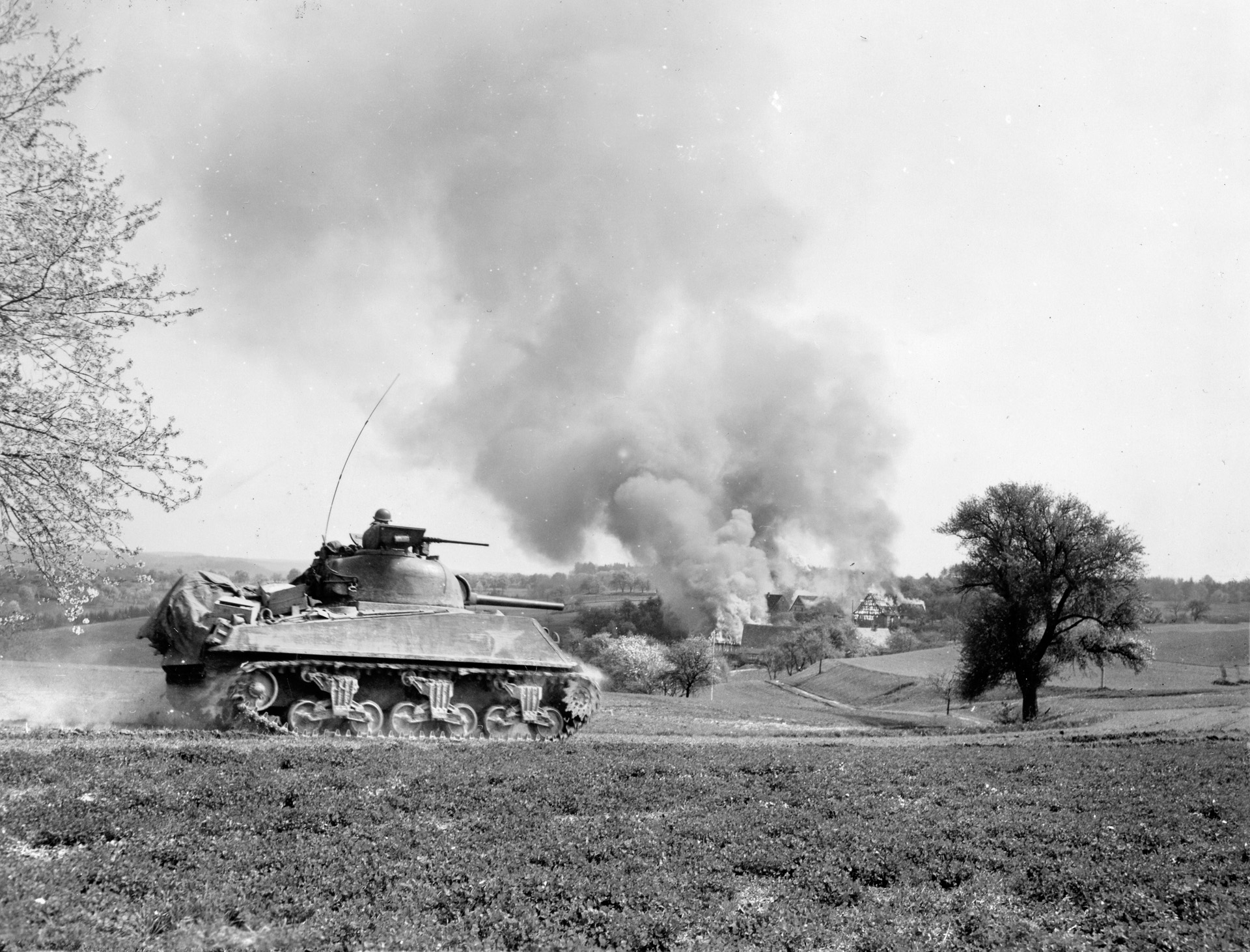 A small German town near Stuttgart goes up in flames as a 21st Tank Battalion Sherman dashes eastward.