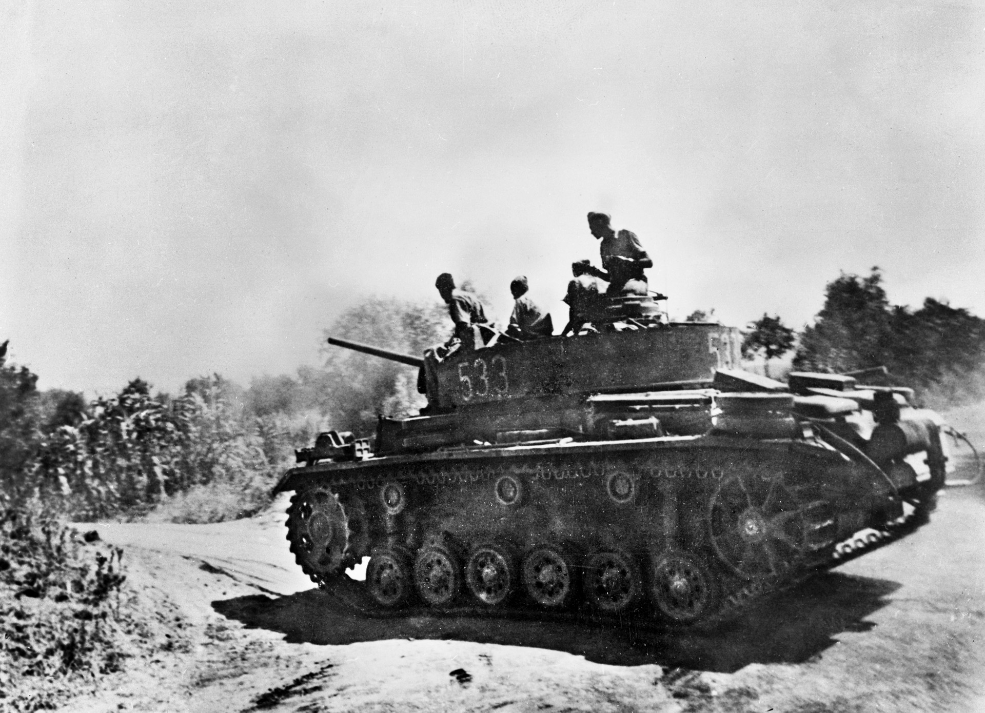 A German Panzer III raises a cloud of dust as it drives towards the U.S. Seventh Army's beachhead. Axis tanks broke through the thin lines at Gela until individual acts of heroism and naval gunfire took a heavy toll on German and Italian armor.