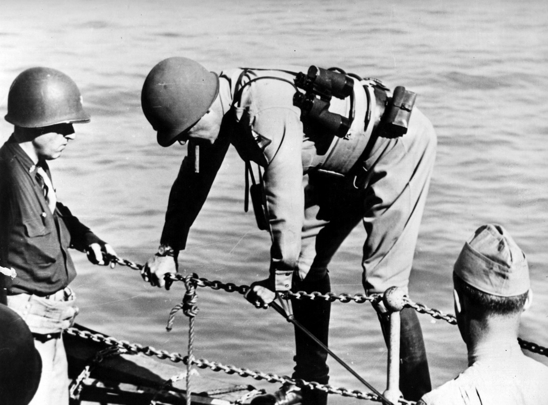 A cigar clenched in his teeth, Patton climbs over the side of the USS Monrovia to a waiting landing craft that would take him to Gela Beach. 