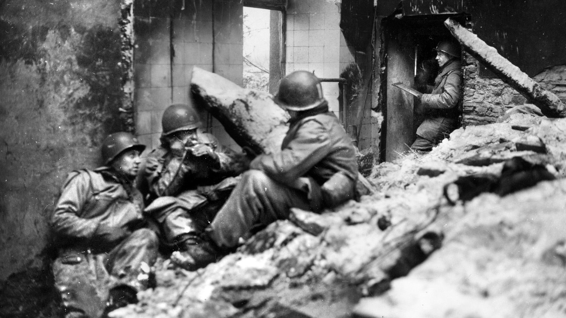 Myers noted that foxholes and the ruins of buildings in Weiler often became the only shelter from the harsh weather conditions. Here an American officer (second from left) uses a field phone to communicate with higher headquarters.