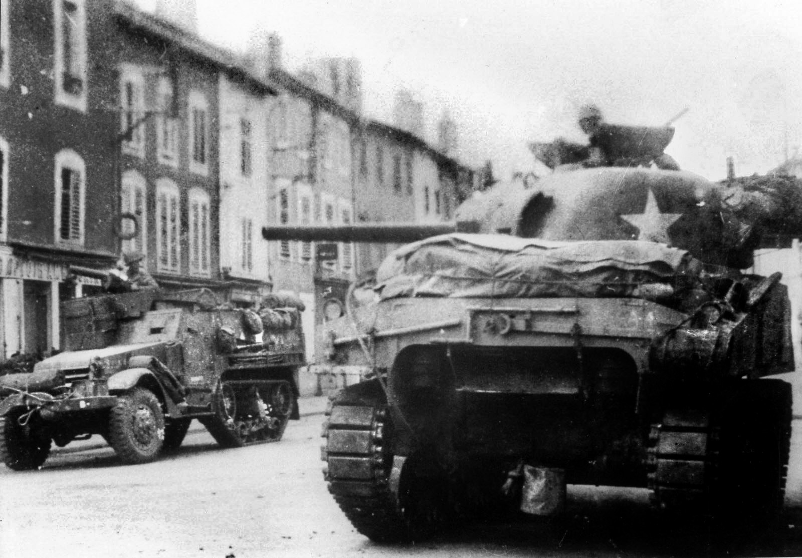 An American tank and halftrack sit motionless on a street in the French town of Luneville. The U.S. 2nd Cavalry Regiment fought a German advance to a standstill in the autumn of 1944, thwarting an attempt to cut off the U.S. 4th Armored Division, one of the premiere fighting units of General George S. Patton’s Third Army. 