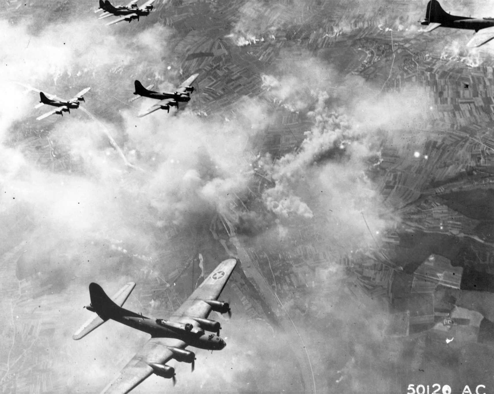 Boeing B-17 heavy bombers stream through the skies above Schweinfurt, Germany, during a bombing mission on August 17, 1943. The mission was one of many costly U.S. Eighth Air Force daylight raids on the Third Reich. 