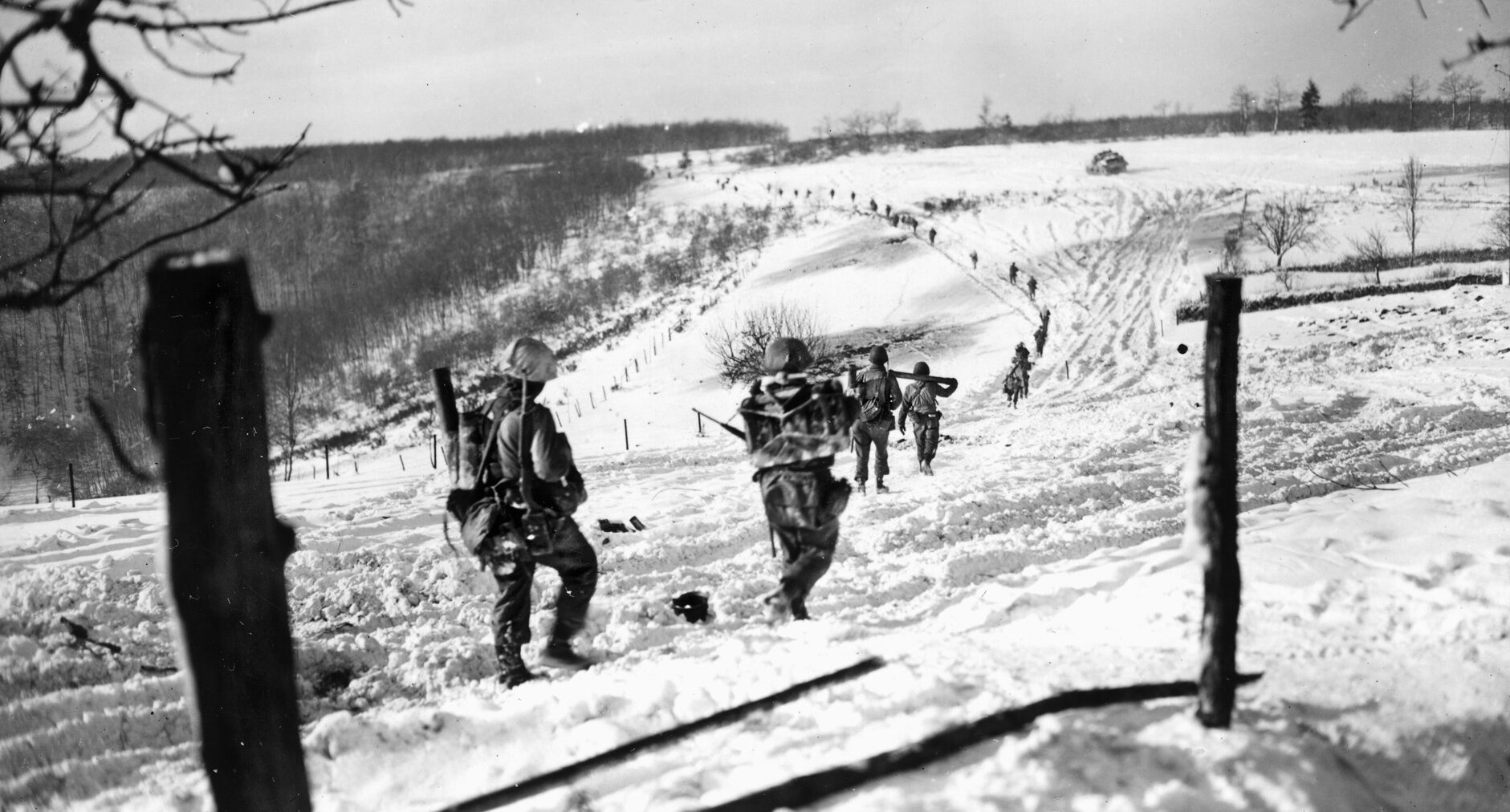  Pressing forward across the wintry landscape in Luxembourg, these soldiers of the 10th Infantry Regiment, 5th Division, follow a tank that is visible in the distance. Once the 5th Division reached the German frontier, the unit crossed the Sauer again in early February 1945 to confront the fortifications of the Siegfried Line.