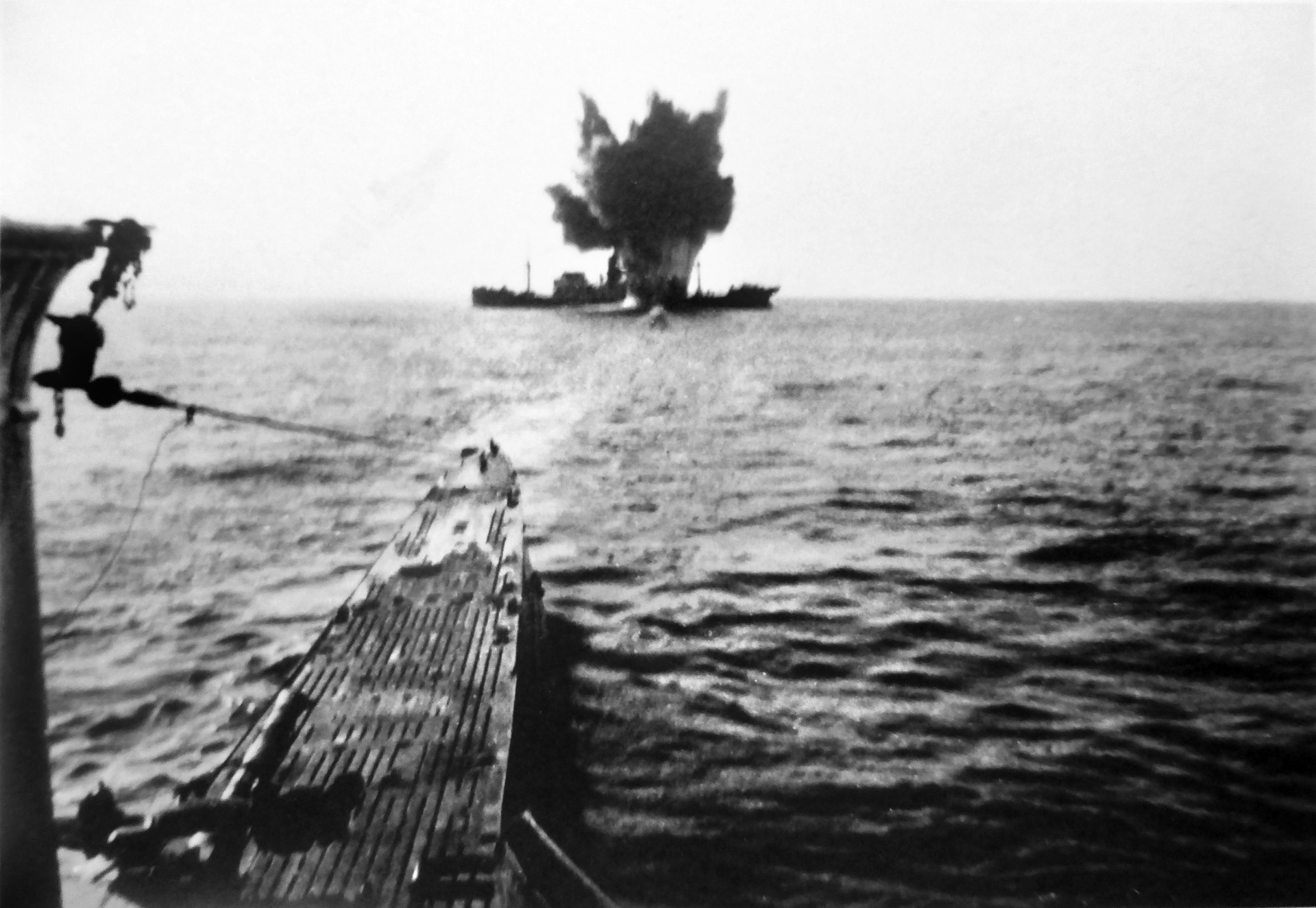 In this photo taken by a crewman aboard a German U-boat on the water’s surface, a torpedo strikes home amidships, dooming an Allied merchant ship to a watery grave. 