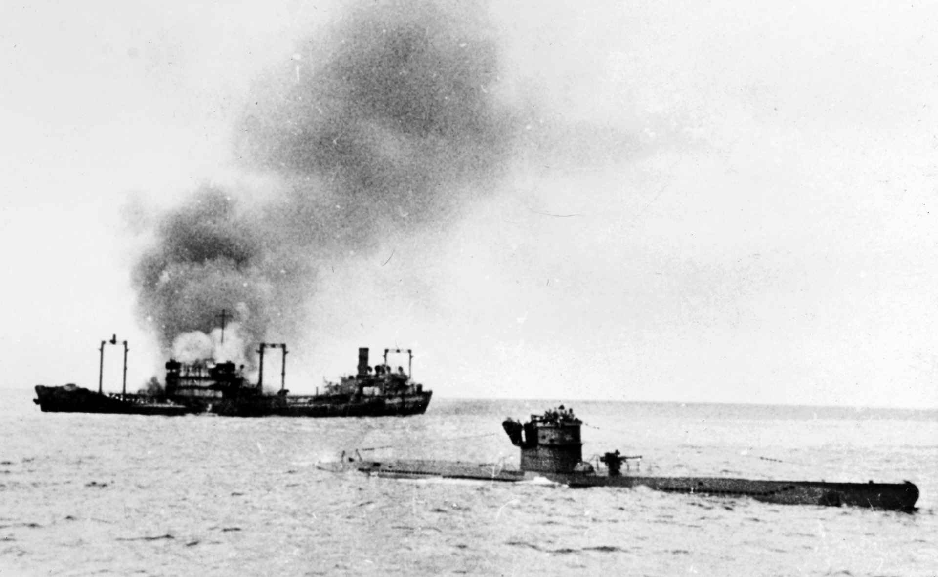 This startling photo depicts the German submarine U-442 on the surface of the Atlantic Ocean in January 1943, just after torpedoing the Allied tanker at left. U-boat captains preferred to launch their attacks on the surface if possible, and in this case the encounter occurred in broad daylight.