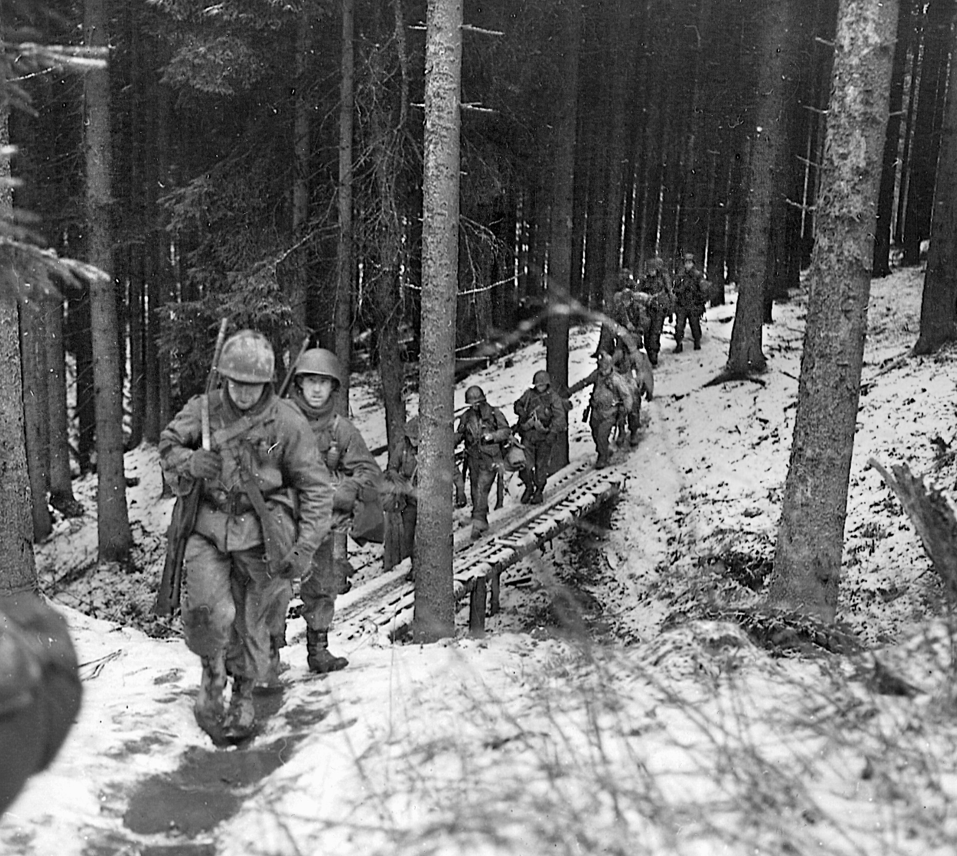 Soldiers of the 106th Infantry Division trudge through the snow in Belgium during the winter of 1944. The inexperienced 106th suffered at the hands of the marauding Germans during the opening hours of the Battle of the Bulge, sustaining 8,627 casualties. The number was the highest for a U.S. combat division in the shortest period of time during the entire war. 