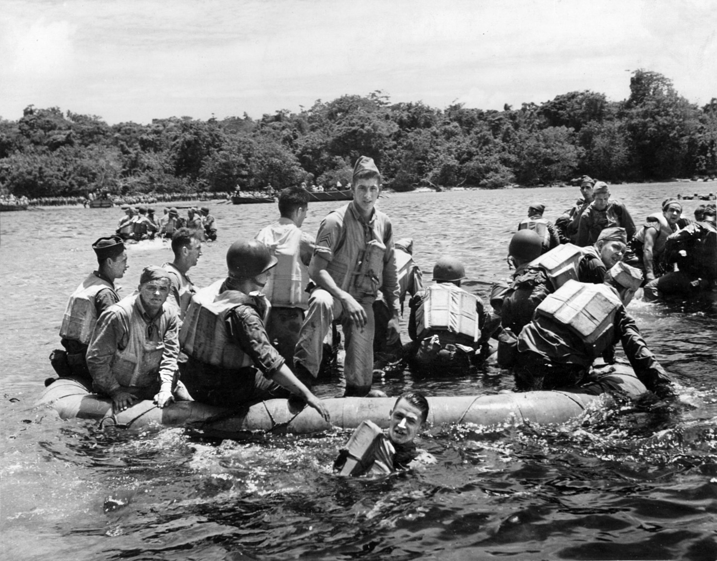 After leaving the sinking transport Coolidge, a group of survivors paddles away from the sinking ship. The ship’s captain insisted on frequent lifeboat drills, which contributed to the orderly evacuation as the ship slowly rolled over.