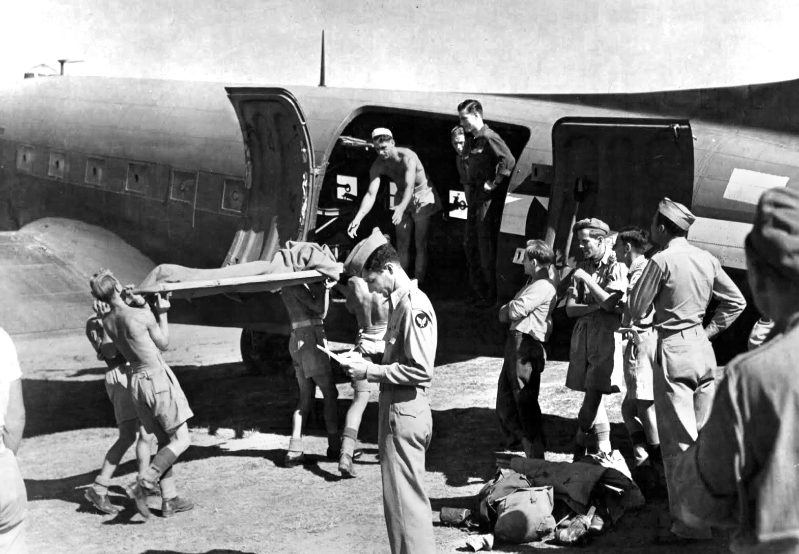 Airmen load a wounded man into a C-47 for transport at an airfield in Yugoslavia. During the course of their rescue operations, the OSS and cooperative Chetniks successfully returned 417 downed airmen from Nazi-controlled territory in Yugoslavia to Allied bases.