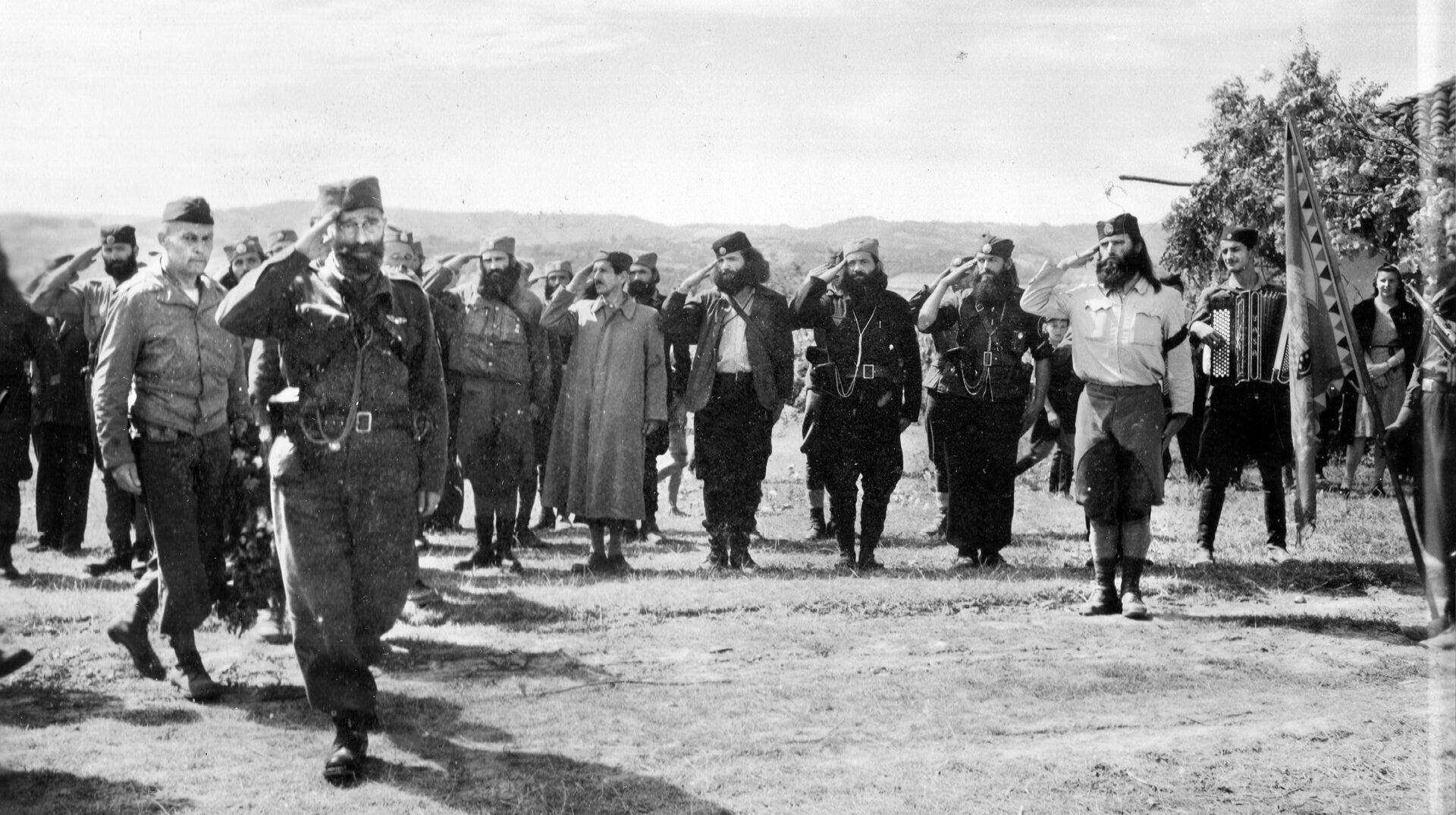 General Drazha Mihailovich, leader of the Chetniks, inspects a group of his resistance fighters somewhere in Yugoslavia. Accompanying Mihailovich is Colonel Robert McDowell of the American OSS covert operations organization. McDowell and Mihailovich cooperated during Operation Halyard to rescue downed Allied airmen in August-September 1944.