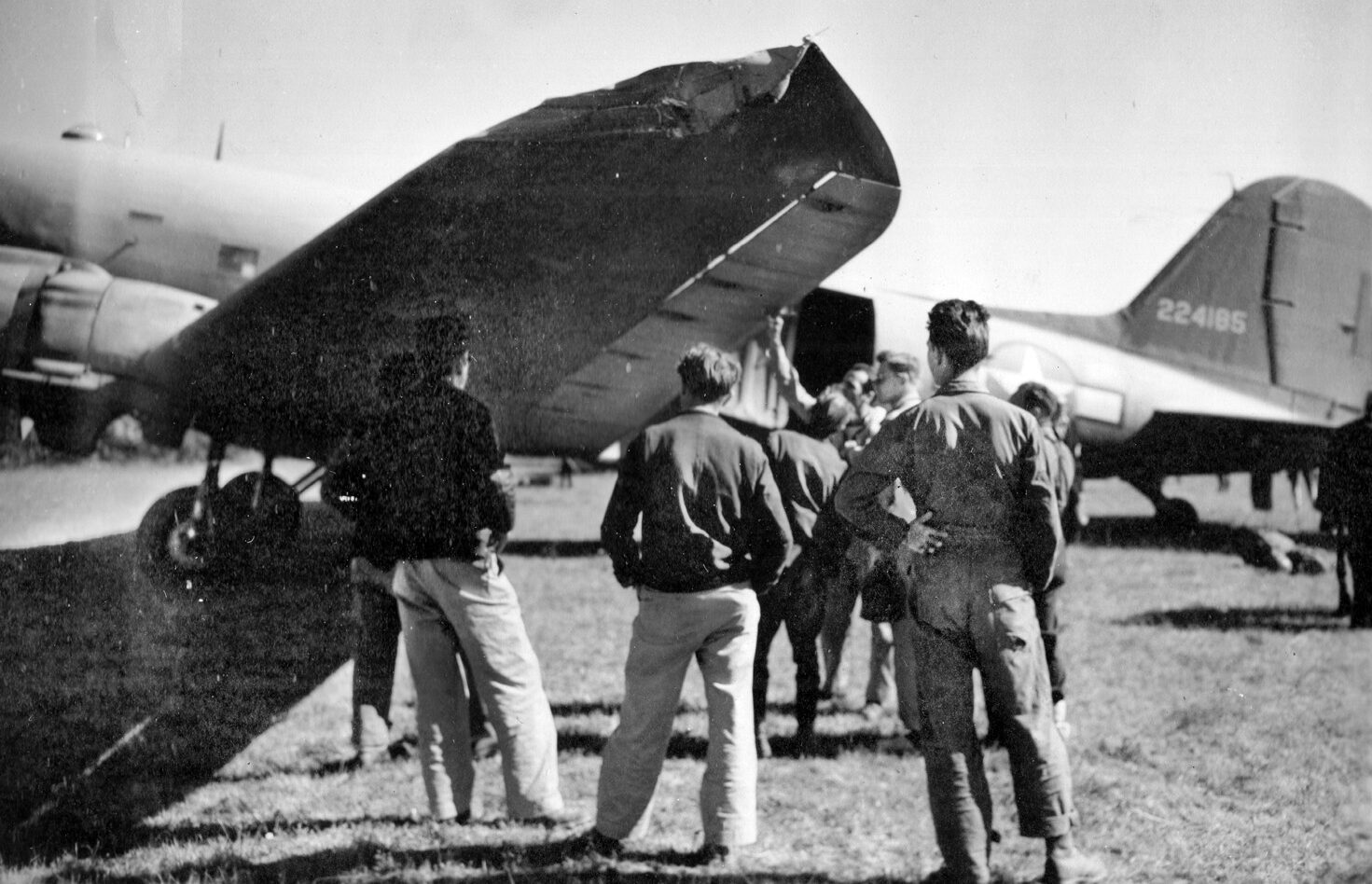 A group of American airmen inspect the damage done to a C-47 transport plane during an Operation Halyard mission. The C-47 clipped a haystack during its landing approach at an airfield near Koceljeva, in what is now western Serbia. 