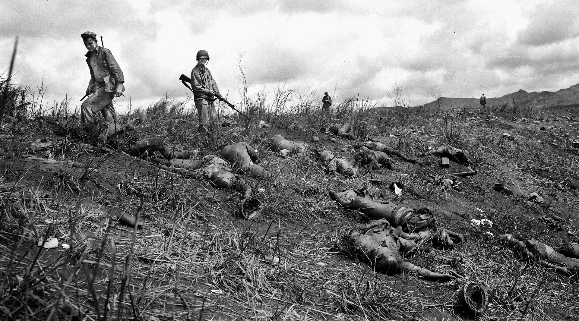American soldiers survey the jumble of Japanese corpses left following a futile banzai charge on the island of Guam. The Marines and Army soldiers faced nightime attacks that ultimately resulted in the slaughter of large numbers of brave Japanese soldiers. 
