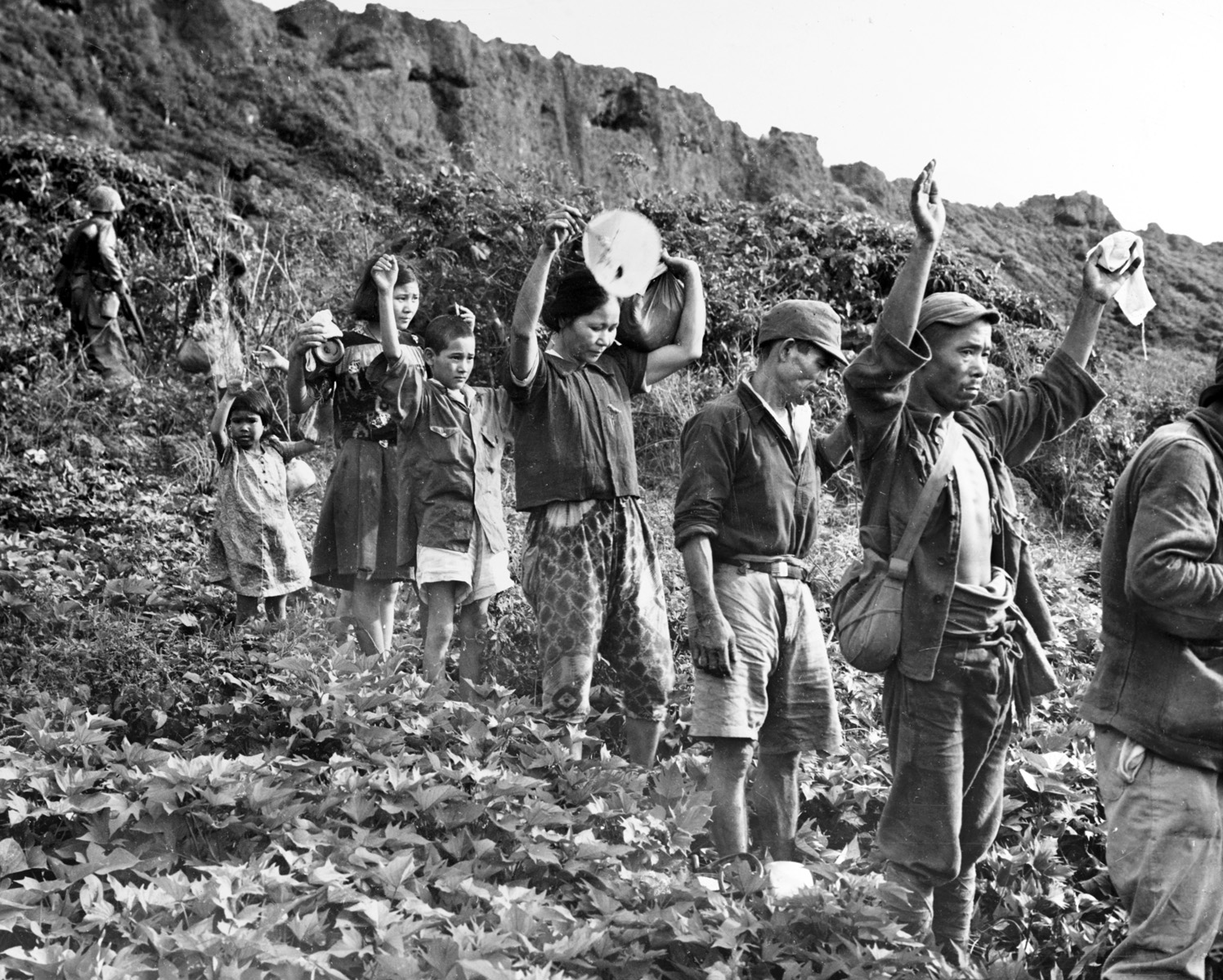 Japanese soldiers and Korean laborers, pressed into service with the Japanese military, emerge from hiding with their hands up. After 21 days of fighting in August and July of 1944, Guam was finally secured. 