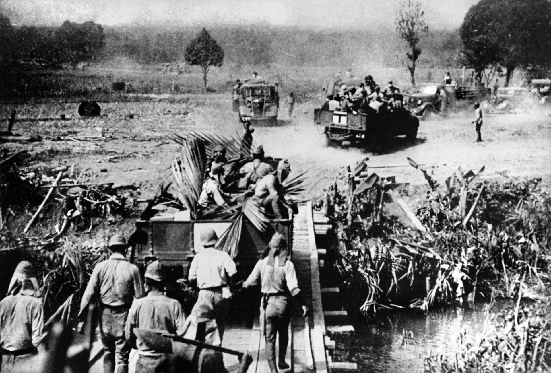 Massing for a general attack on American and Filipino positions on the Bataan Peninsula, Japanese soldiers move toward jumping off positions aboard trucks and on foot.