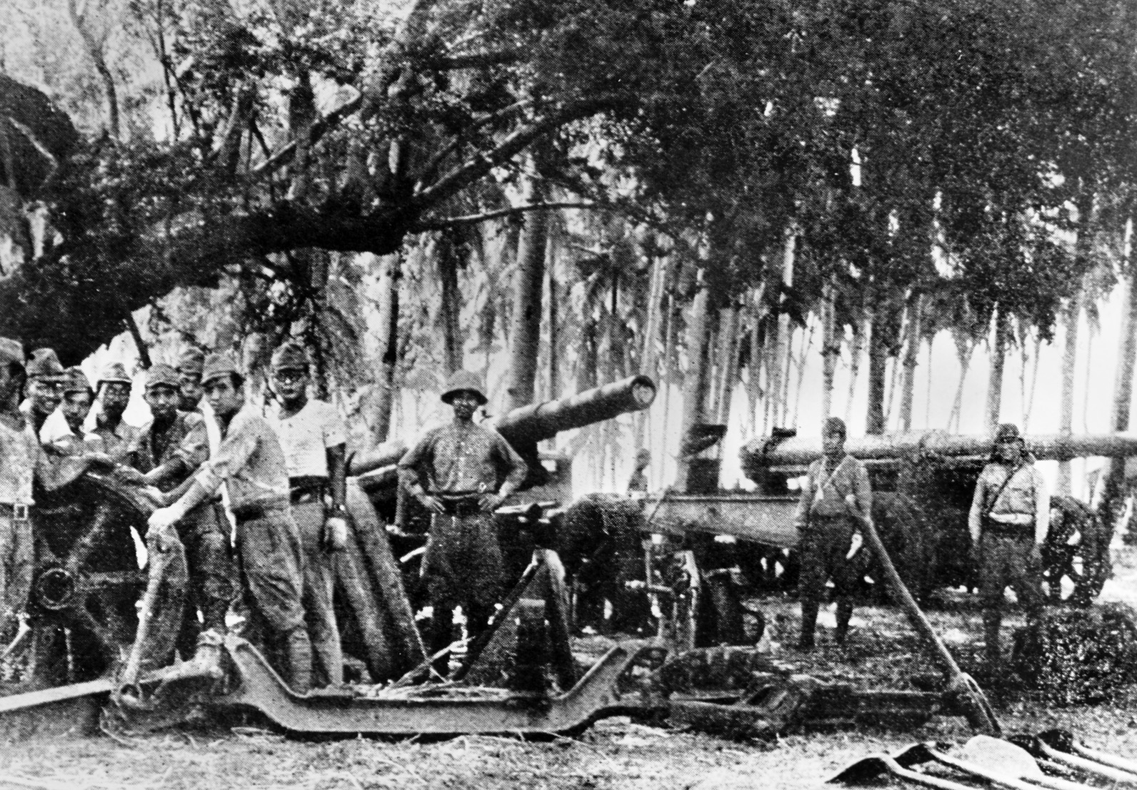 Japanese soldiers man field artillery pieces set to bombard American and Filipino defensive positions in the Philippines.