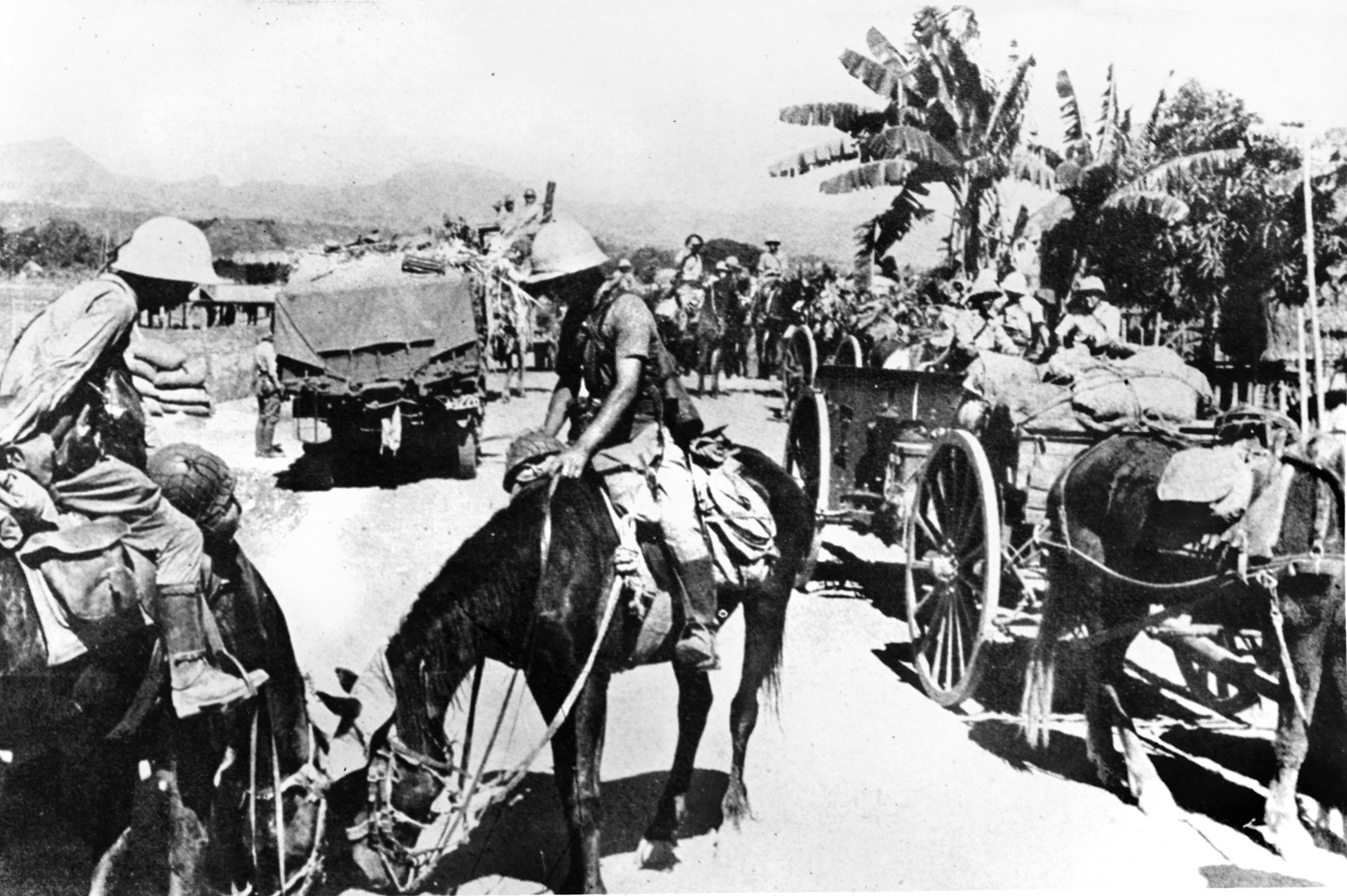 Japanese soldiers, some mounted on horseback, prepare to resupply their troops fighting on the front lines against the American and Filipino defenders of the Bataan Peninsula and the island of Corregidor.