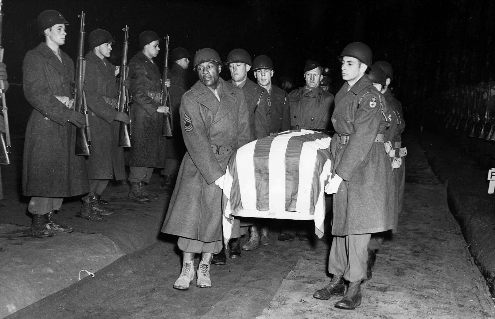 Pallbearers carry the casket of General George S. Patton to his burial plot on December 24, 1945.  During the funeral Bush marched behind a halftrack bearing Patton’s flag-draped casket on its way to the Hamm military cemetery in Luxembourg.