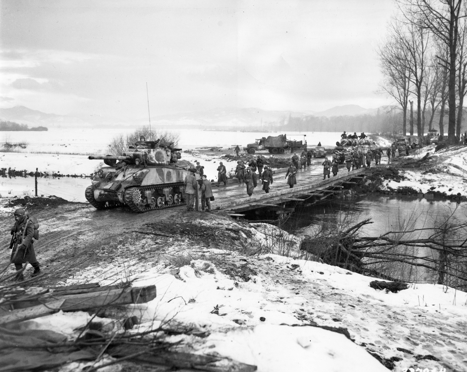 Soldiers with the 75th Infantry Division advance through Riedwihr, France. To keep warm, Bush and his comrades would gather behind German tanks and enjoy the heat from their exhaust.