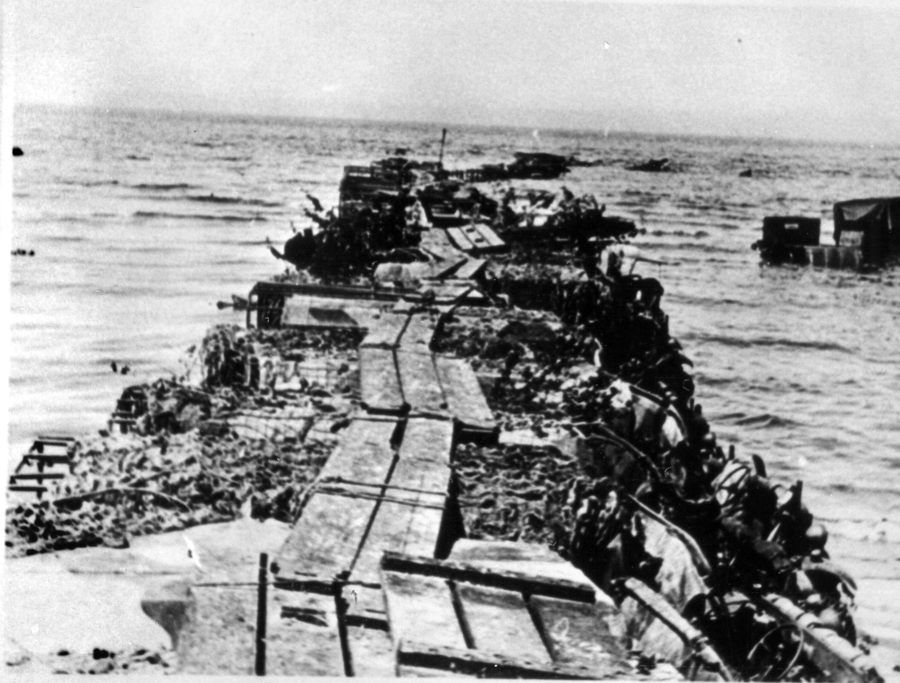 This makeshift jetty was constructed atop vehicles driven into the waters of the English Channel at Dunkirk allowing soldiers to board ships more quickly.