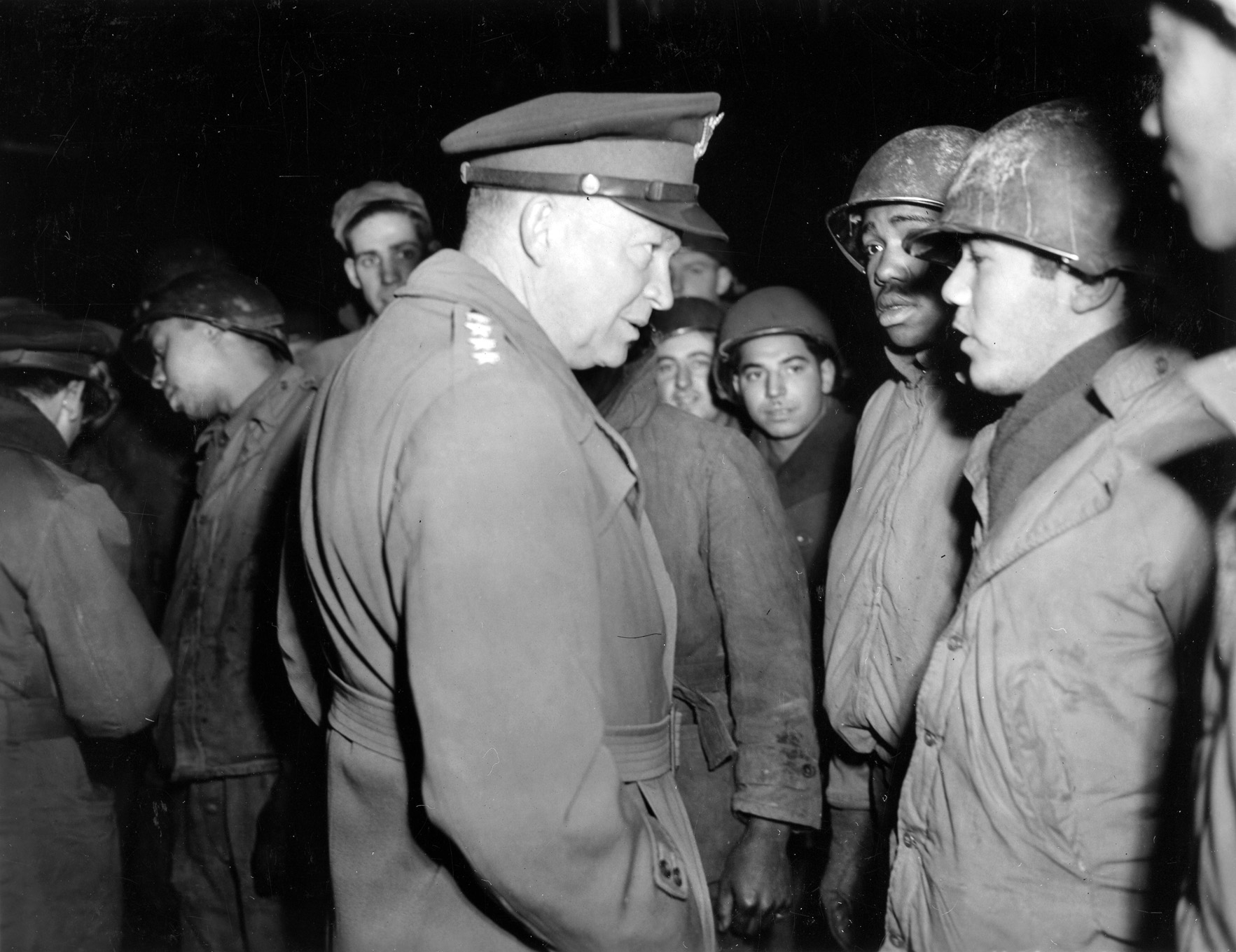 Eisenhower discusses salvage operations with Tech5 Ralph Austin of Seattle, Washington, with the 945th Quartermaster Salvage Repair Company. 