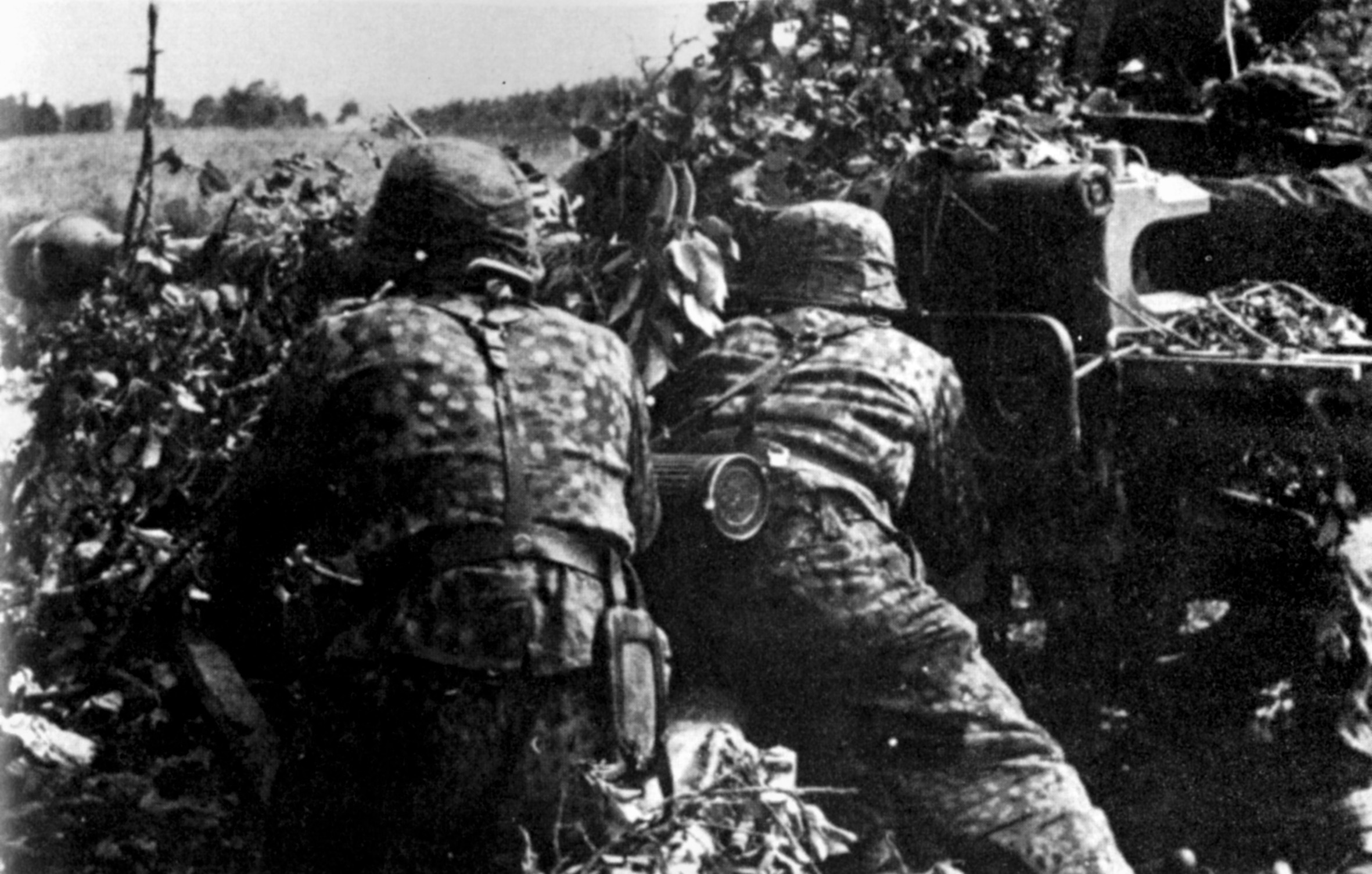 Manning a 75mm anti-tank gun, soldiers of the Waffen SS lie in ambush as they await advancing Soviet tanks and armored vehicles.