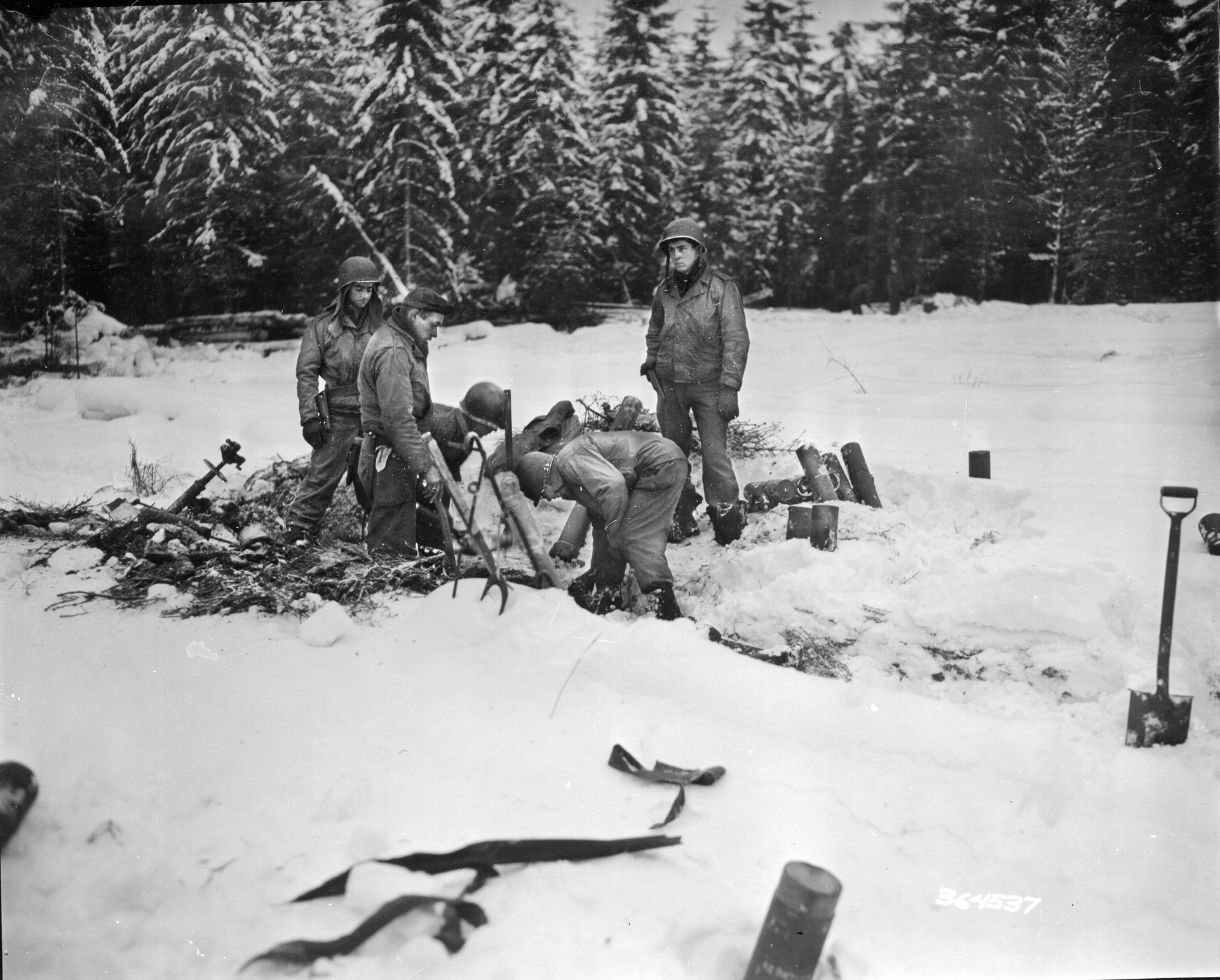 American soldiers set up a mortar in a wintery landscape. Freeman set up his mortar in the Bois Jacques (Jack Woods), ready to drop mortar rounds anywhere his company commander requested.