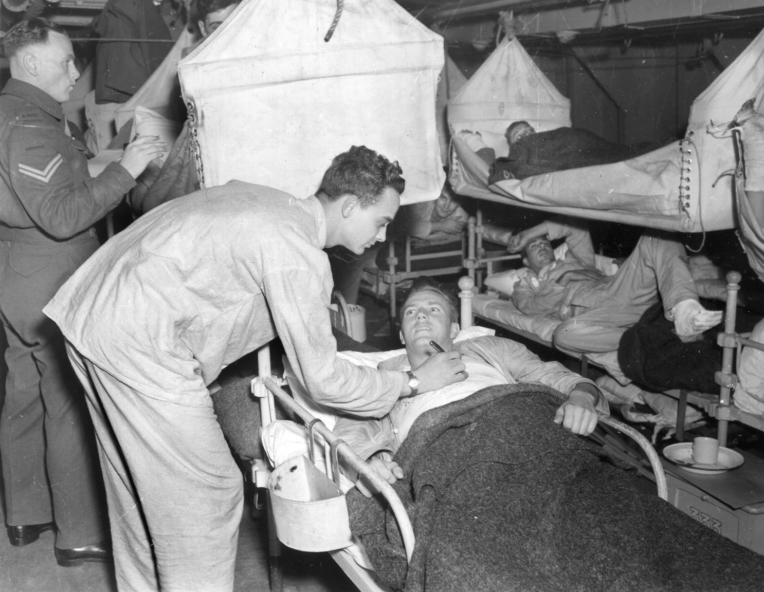 One GI signs the chest cast of another on board a hospital ship bound for England. Freeman made a similar journey when he shipped out for England for three months of treatment on his wounded leg.