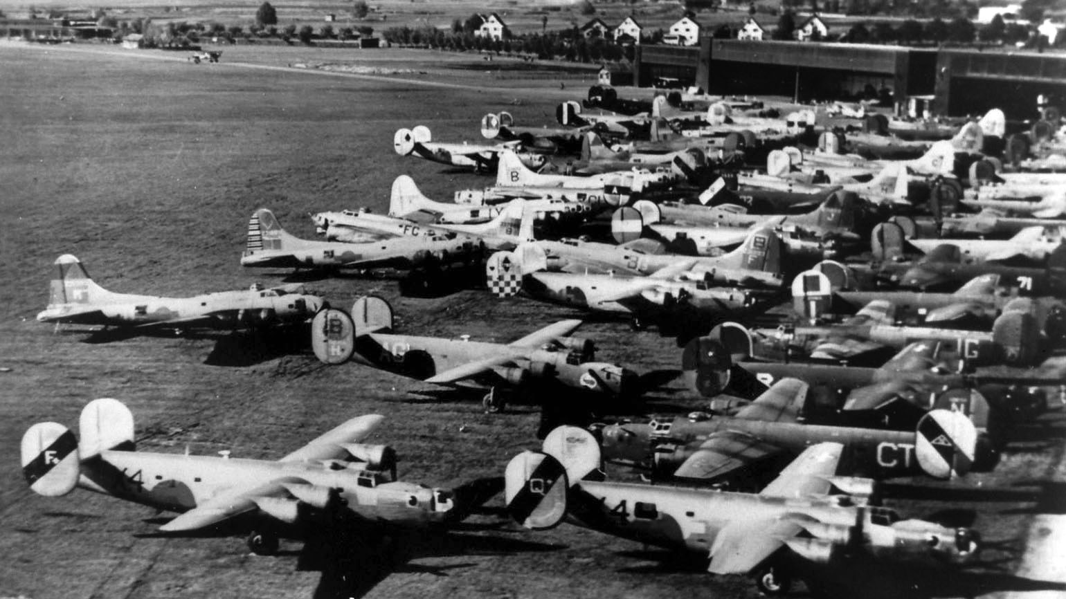 A collection of American aircraft interned in Switzerland during the war sits idle at an airfield  somewhere in the neutral country.