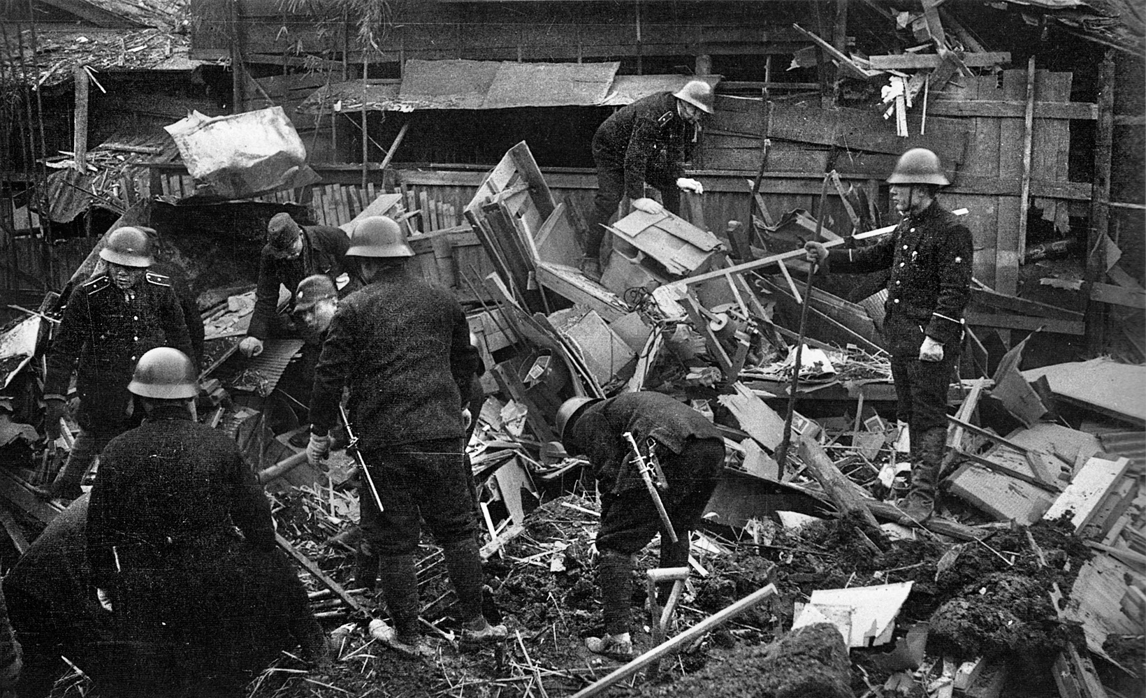 Firemen and Civil Guards attempt to find victims in the wreckage of a Tokyo building. 