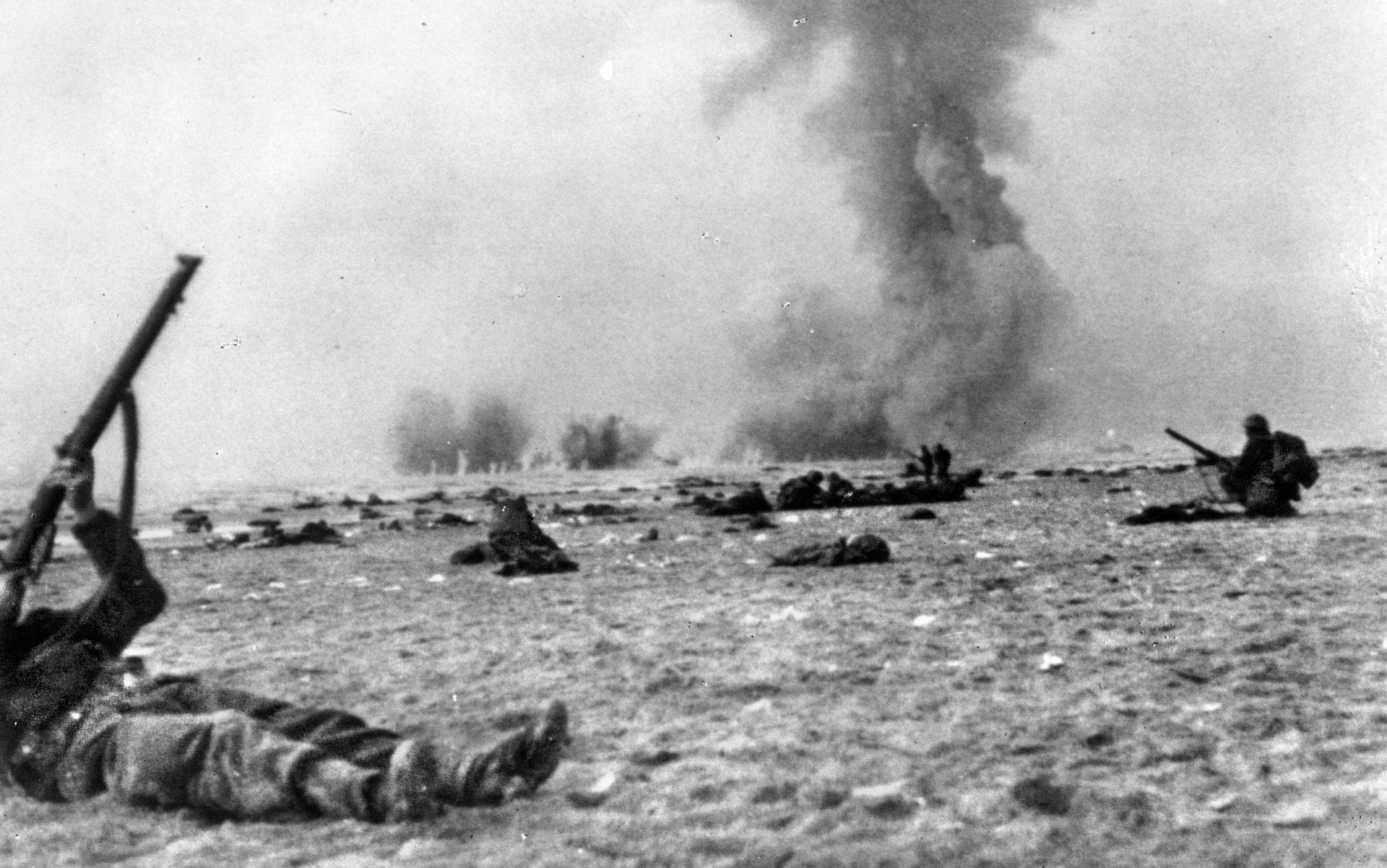 British soldiers, trapped in the open on the beach at Dunkirk, fire their rifles at low-flying German fighter planes intent on strafing them. British veterans remembered that the rifle fire had the desired effect of driving away some aggressive German pilots.