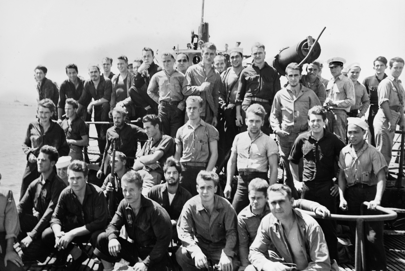 After their baptism of fire at Makin, some members of the 2nd Marine Raider Battalion bear the stoic gaze of combat veterans aboard the submarine USS Nautilus as they enter Pearl Harbor on August 25, 1942. A Marine at left is holding a captured Japanese Arisaka rifle.