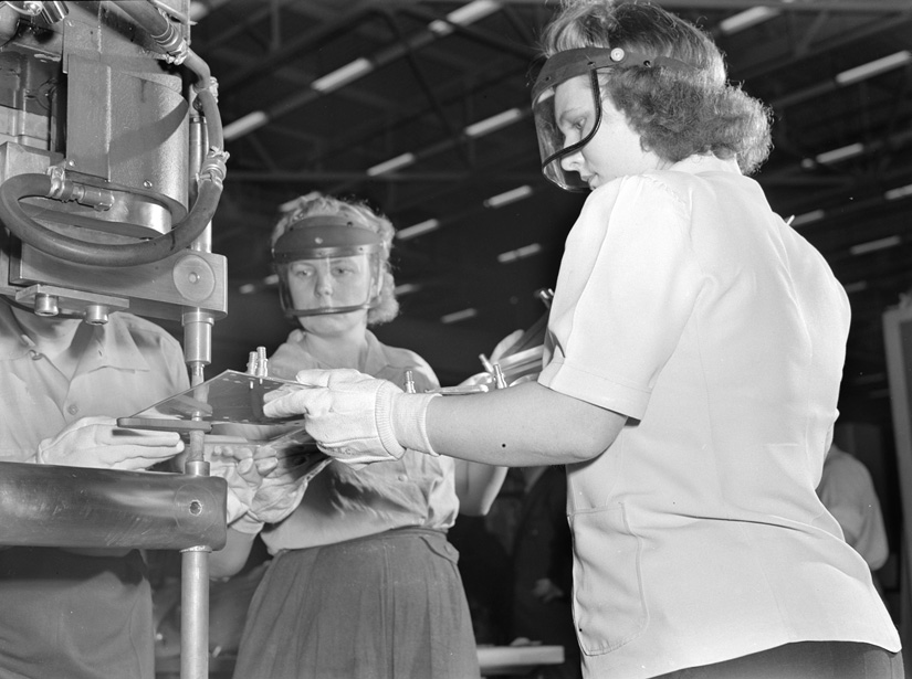 Women in the factory use a spot-welding machine, 1942.