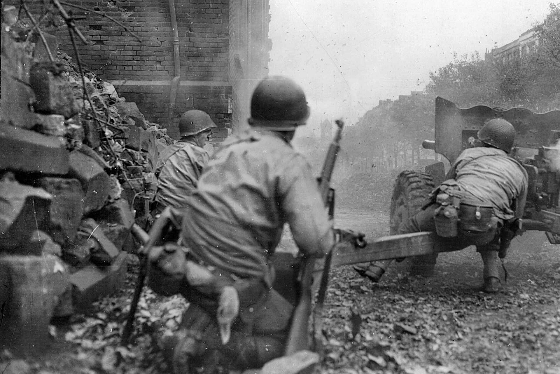 American soldiers fire a 57mm antitank gun against a German strongpoint in the battle down an Aachen street. 