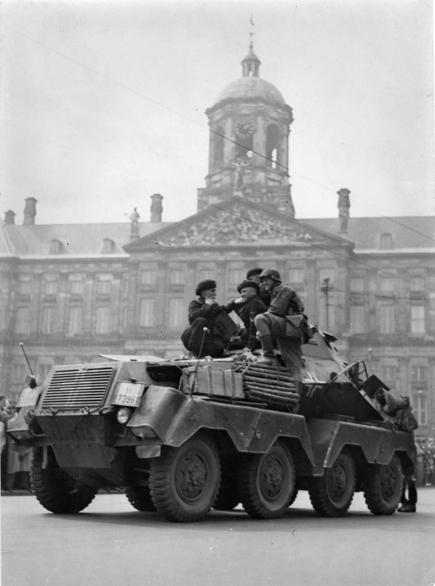 Scout troops clad in panzer uniforms and berets sit atop an SdKfz.231 (8-rad) heavy armored reconnaissance vehicle.