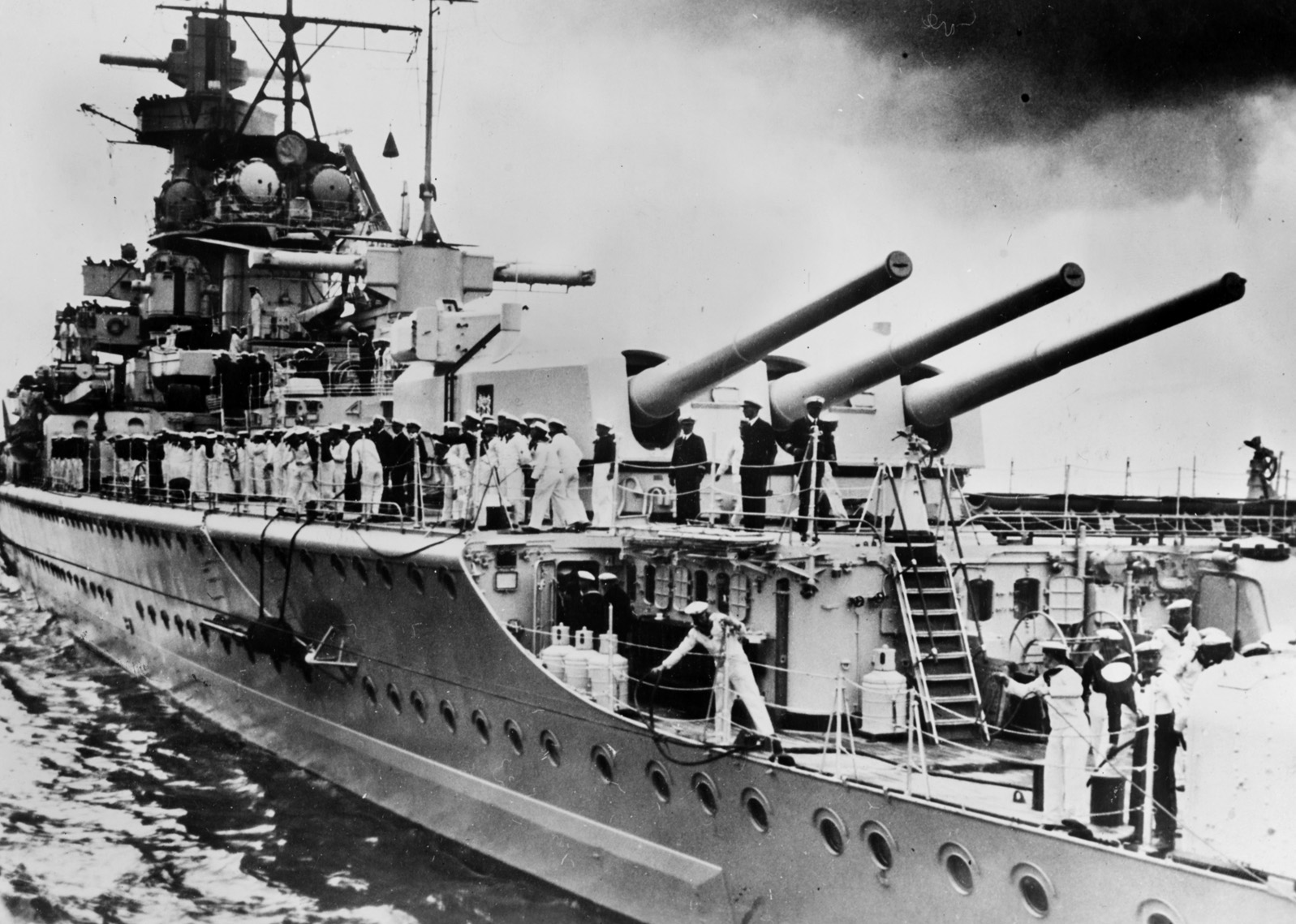 With a number of its crewmen on deck, the Graf Spee is shown in European waters in mid-1939. The German surface raider was armed with menacing 11-inch main guns. These had greater range than the guns of the Allied cruisers that faced Graf Spee off the River Plate. 