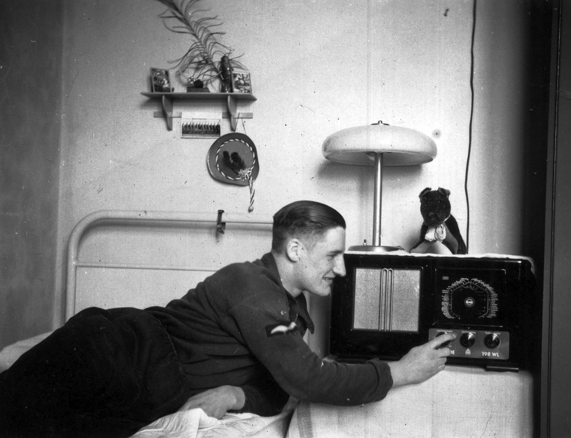 A soldier has a high-end, advanced shortwave radio capable of tuning in the world, although certain stations were verboten. Nazi Germany had the densest “radio population” of any country. In great part this was spurred on by the State’s program for the mass production of low-cost “peoples’ radios.” By 1942, of some 23 million German households, 16 million had radios, making Third Reich indoctrination by radio almost all pervasive. Hitler, rumored killed in the July 20, 1944, plot, dispelled that notion by speaking by radio to the nation. The German radio system functioned to the end when it announced Hitler’s real death—the last broadcast of the Third Reich.