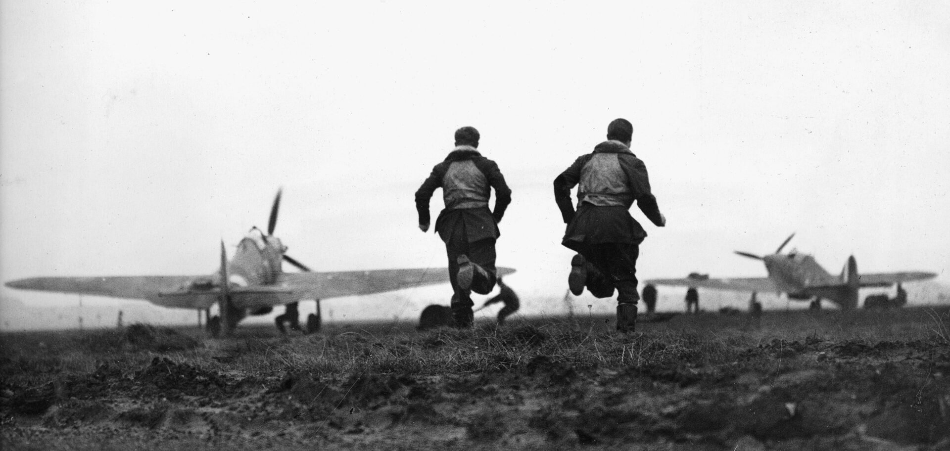 “Ring the bell and run like hell.” Two pilots sprint to their awaiting Hurricanes as ground crew members prepare their planes for flight—and another fight with the German “bandits.”