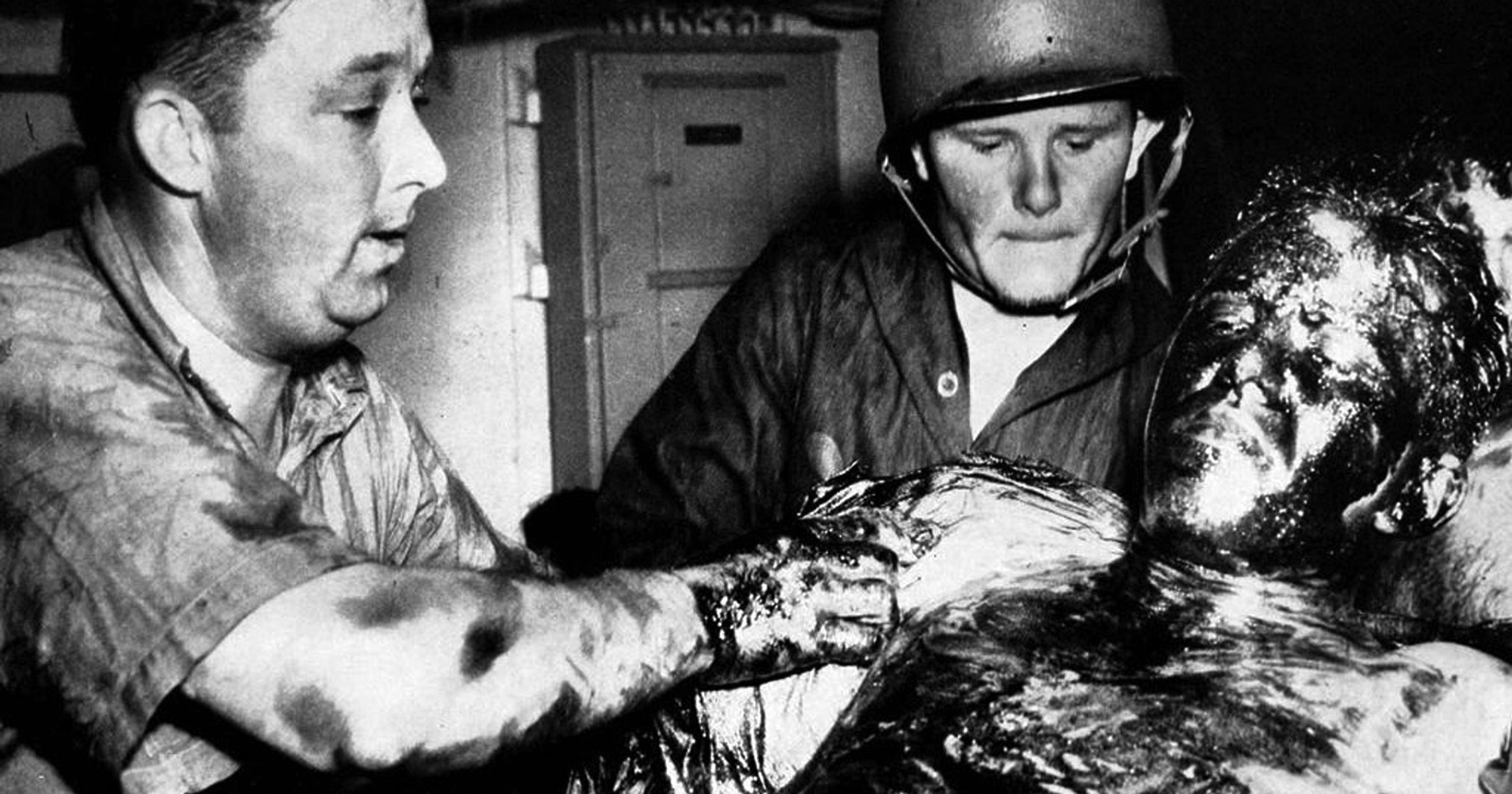 U.S. Navy corpsmen treat an Indy survivor. Many who were pulled from the water were covered with oil and had shark bites and infected saltwater ulcers.