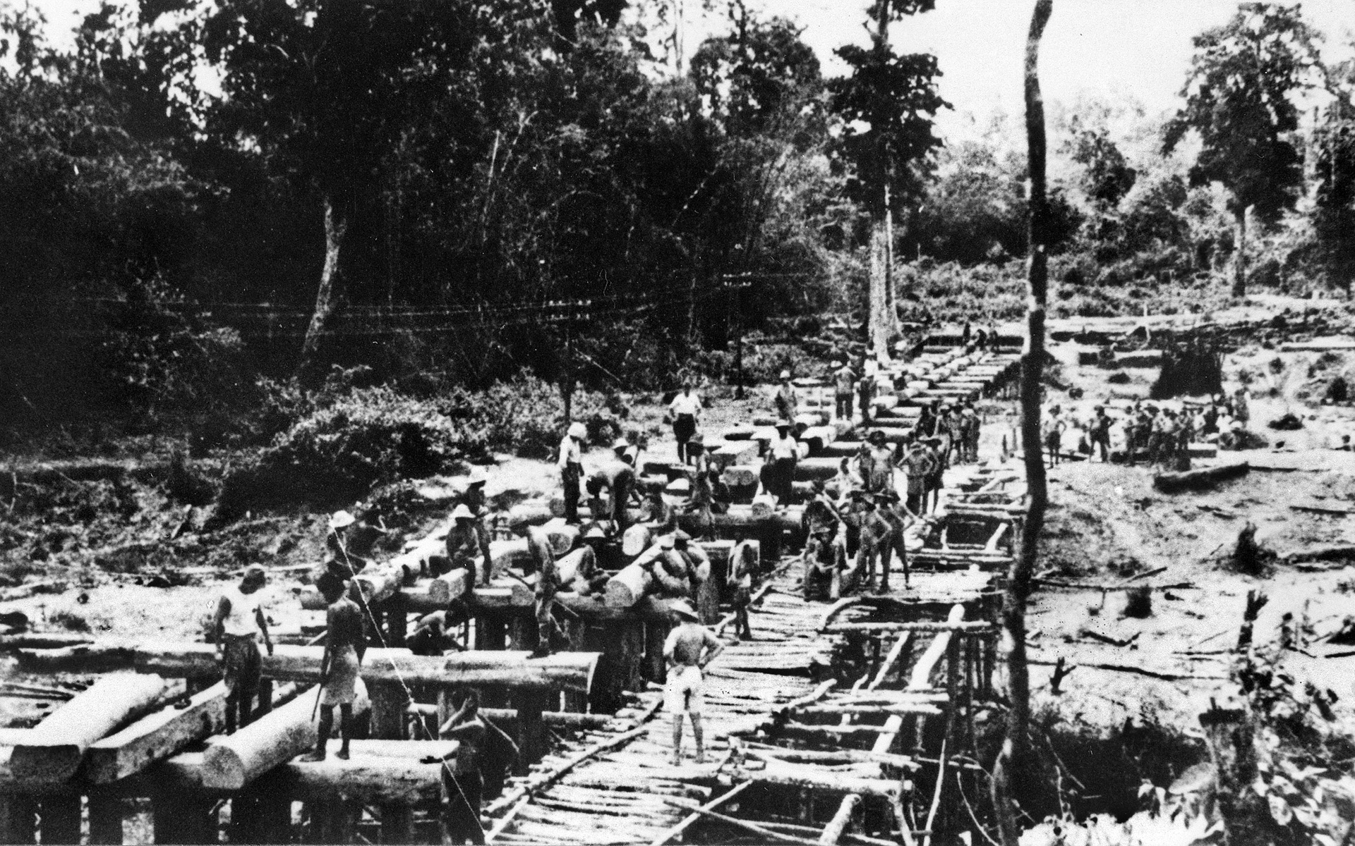 Prisoners move heavy logs during the construction of one of the many bridges built over several rivers. Virtually all the work was labor intensive and performed by hand.