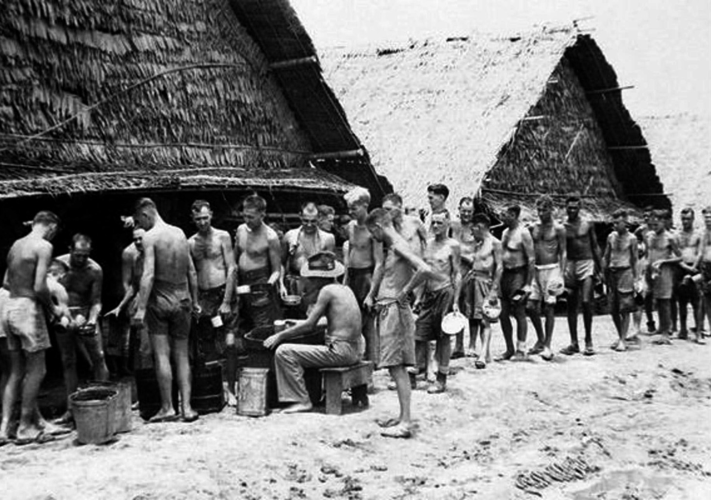 POWs line up for a meal at one of the camps along the Burma-Thailand railway. Each prisoner was supposed to receive 680 grams of rice, 520 grams of vegetables, and 110 grams of meat or fish daily—portions that were rarely reached.