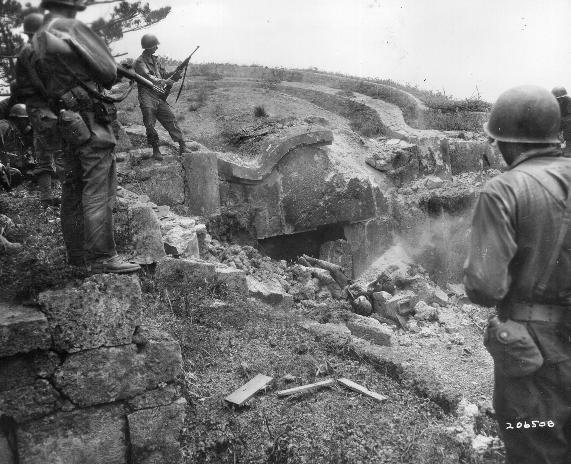 Men of the 106th Infantry Regiment view the bodies of two dead Japanese snipers during the advance on April 19 and reduction of the Kakazu Pocket. The 27th Infantry Division would continue to battle for Okinawa until September 7, 1945. 