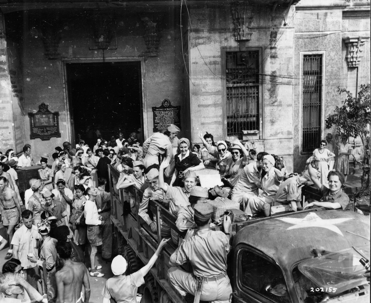 Jubilant American nurses, freed from Japanese captivity at Santo Tomas University, board vehicles to begin their journey home. Many of the Americans at Santo Tomas had endured nearly three years as prisoners of the ruthless Japanese. 