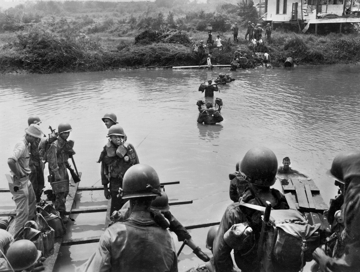 American soldiers of the 37th Infantry Division cross the Tuliahan River on February 4, 1945. Although the advance proceeded with all haste, pockets of Japanese resistance slowed the liberation of the city.