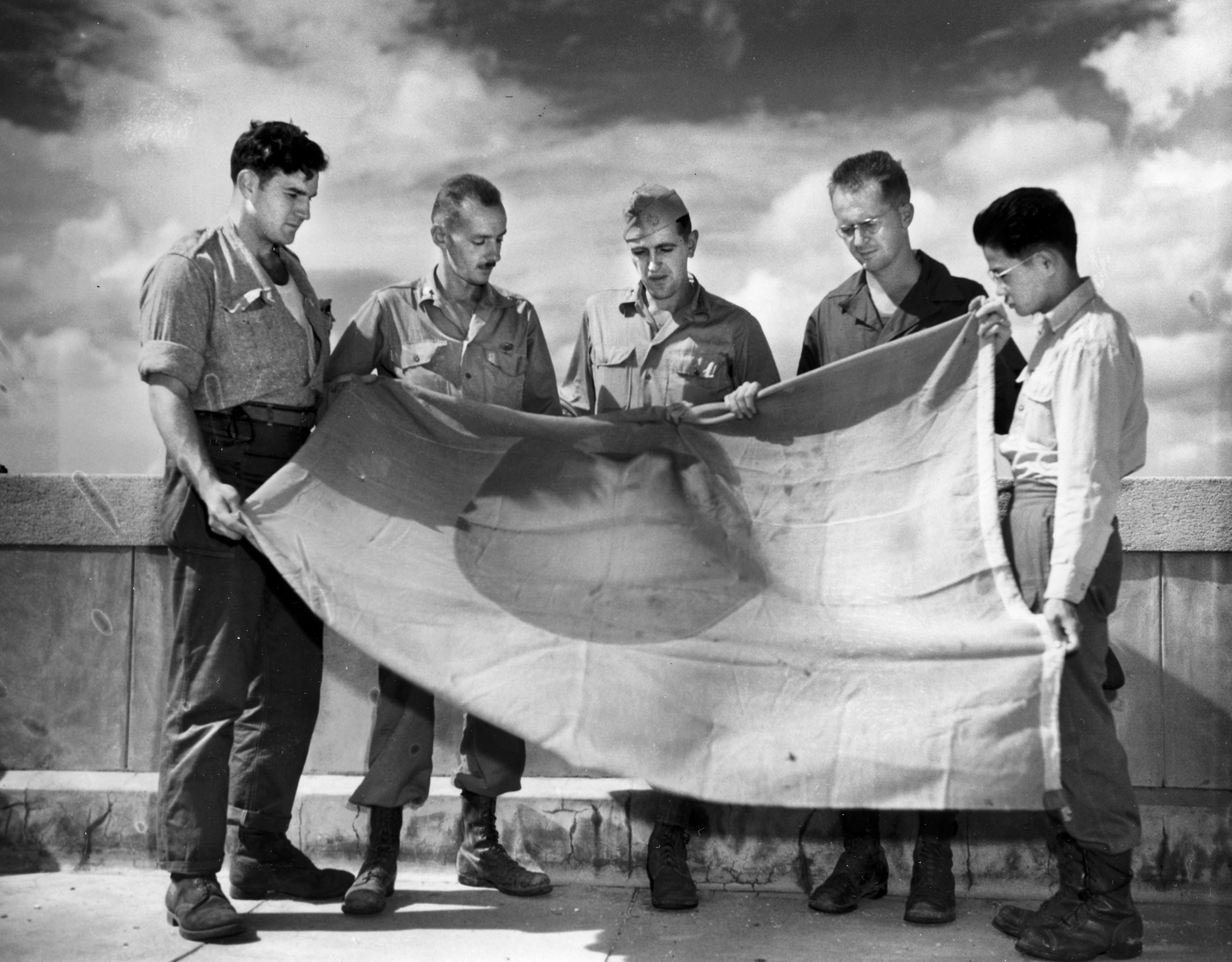 Members of the “Cardinal Team”—a group charged with rescuing POWs held in China—pose with a Japanese flag. Sergeant Hal Leith is second from right.