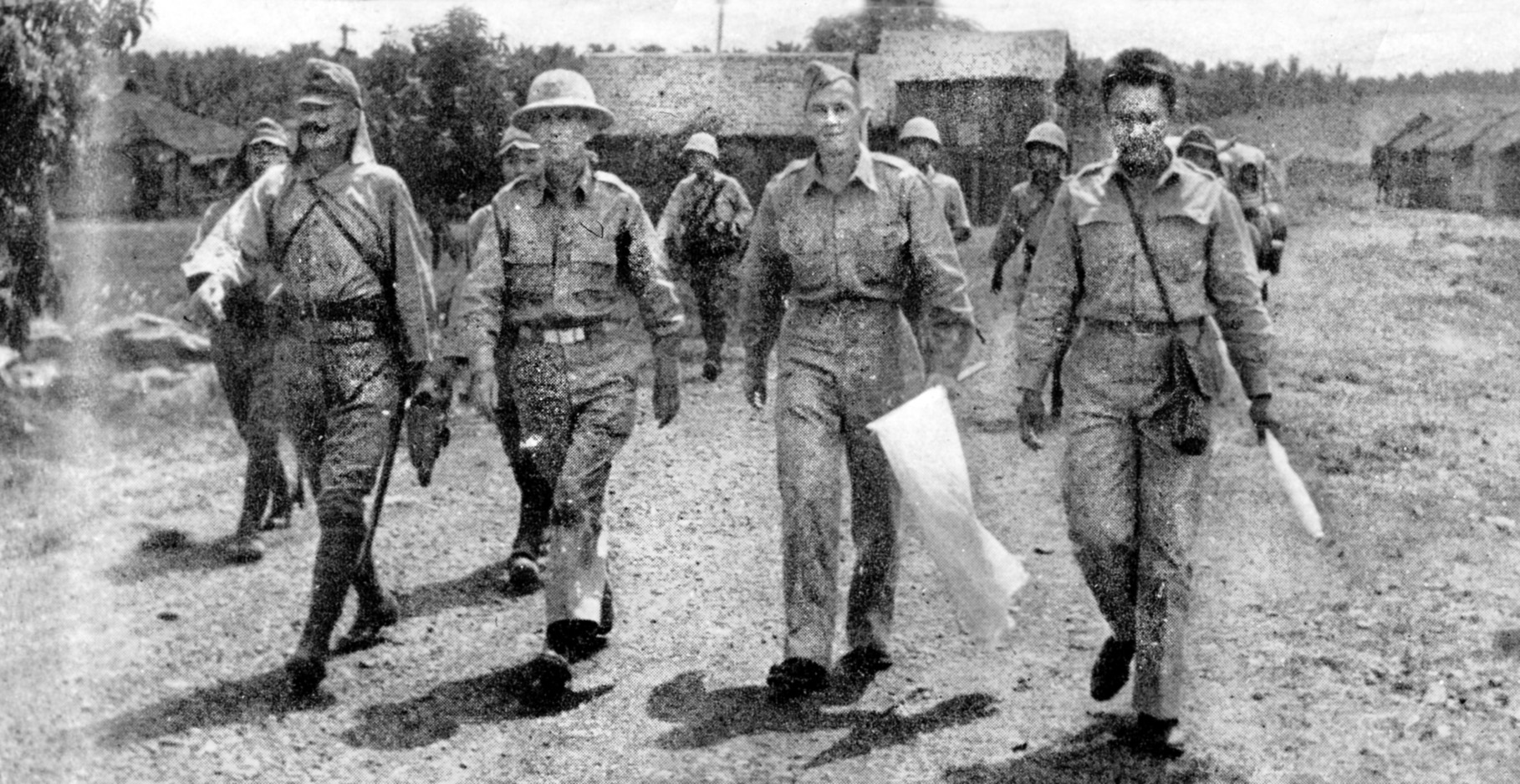 Abandoned by the U.S., American officers are led by their Japanese captors to sign surrender terms on the Bataan Peninsula. 