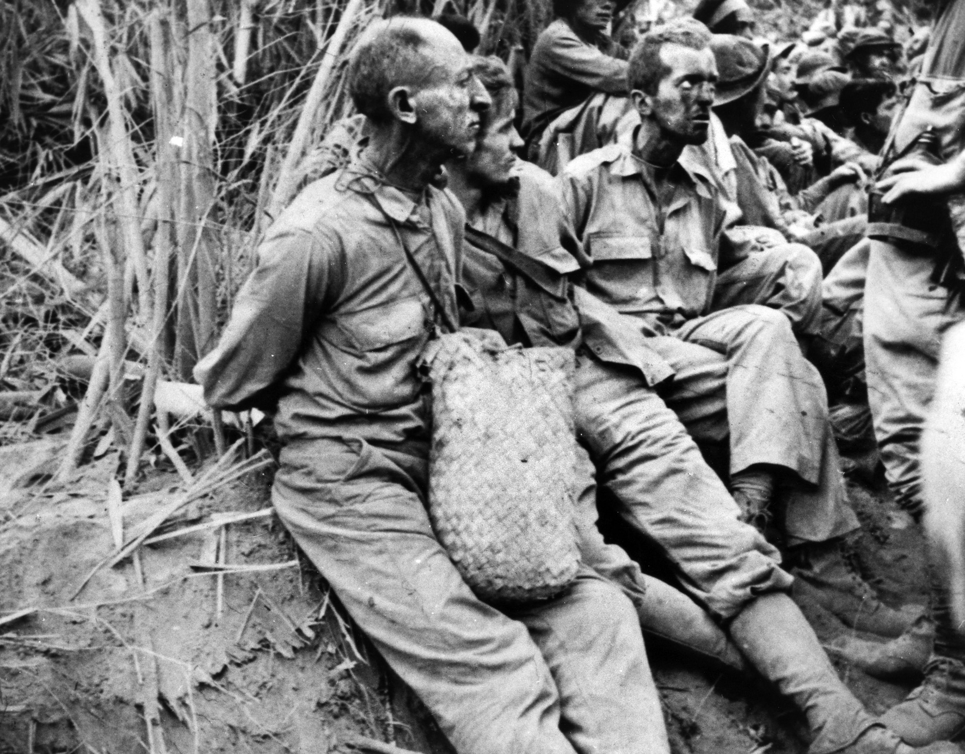American soldiers, their hands tied behind their backs, briefly rest during the 66-mile Bataan Death March from Saysain Point, Bagac, Bataan and Mariveles to Camp O'Donnell, Capas, Tarlac, Philippines. Of the 76,000 men who began the march, some 3,000 perished along the way.