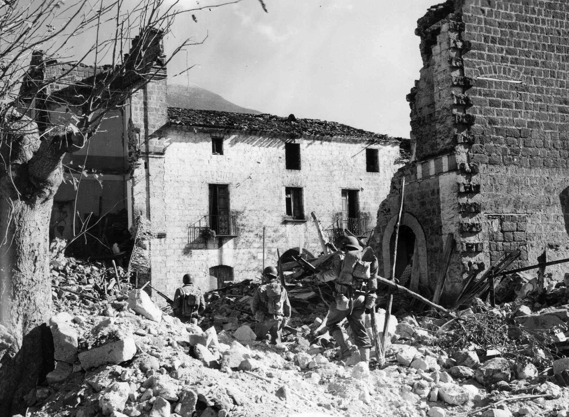 Infantrymen of the 3rd Division pick their way through the rubble of Mignano, Italy, after heavy shelling by both German and American artillery. Larimore joined the division in Naples in February 1944.