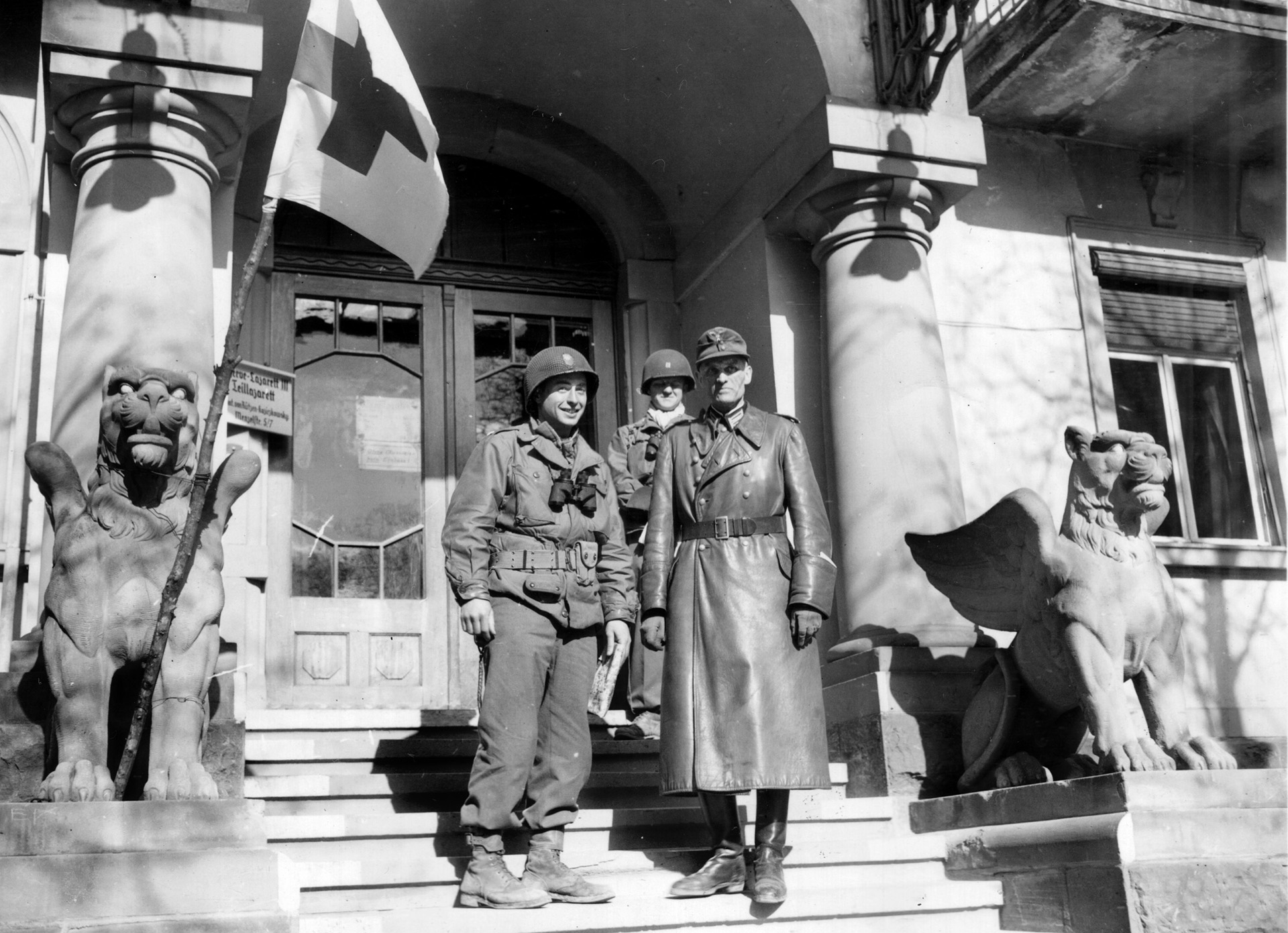 Lieutenant Colonel Chaney Christopher accepts the surrender of German forces in the town of Bad Kissingen, Germany, while standing in front of the local hospital. Larimore and his command found American casualties in the hospital after capturing the town.